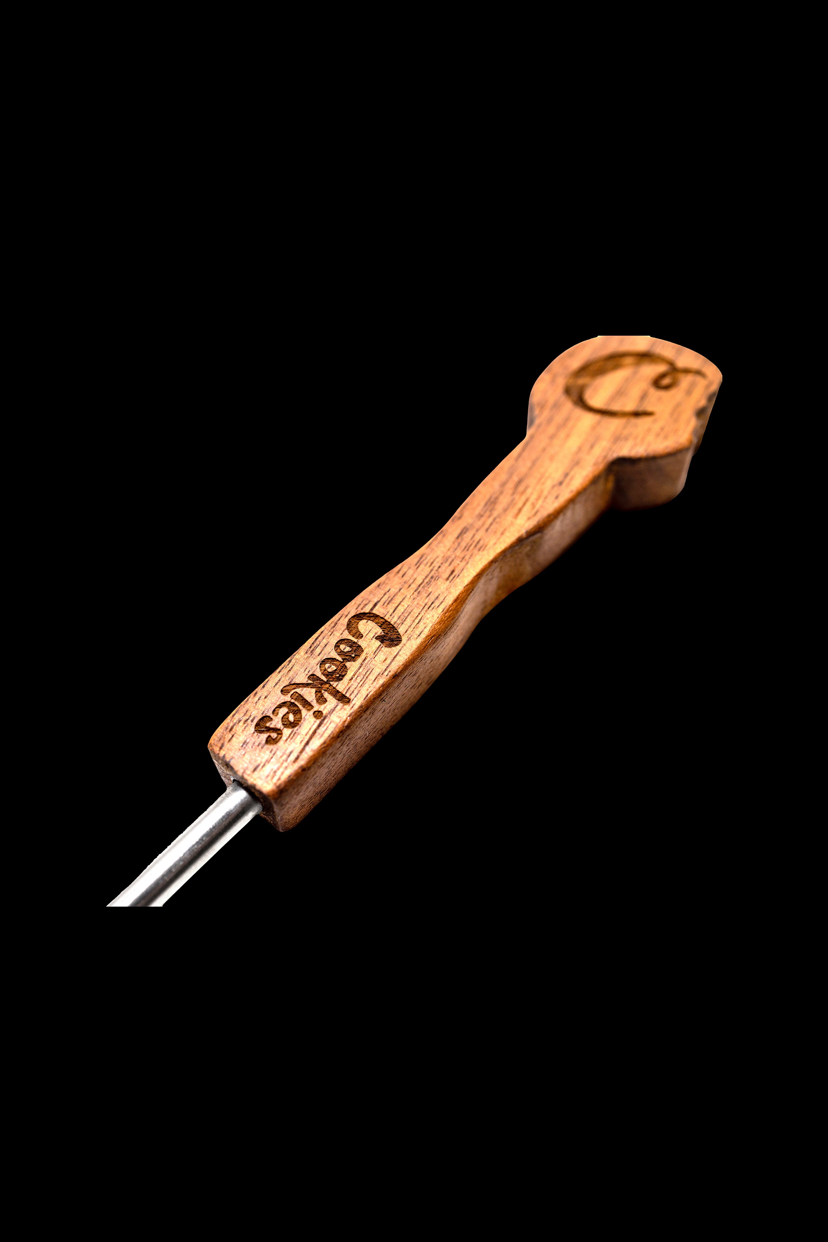 Wooden dab tool with “Cookies” branding and metal tip against a black background.