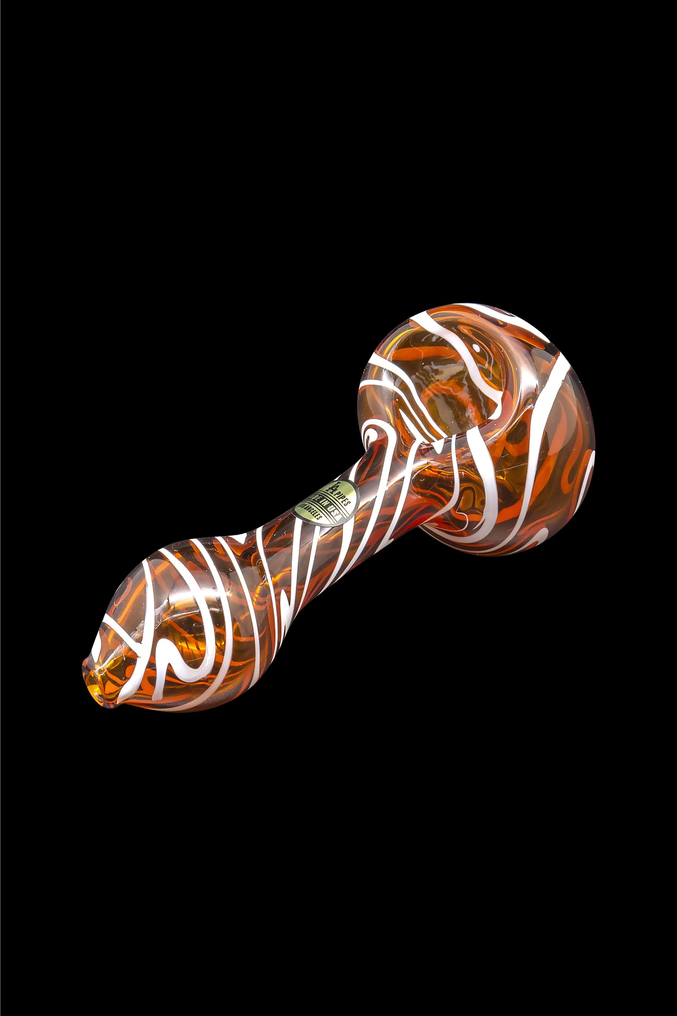 Orange and white swirled glass pipe isolated on a black background.