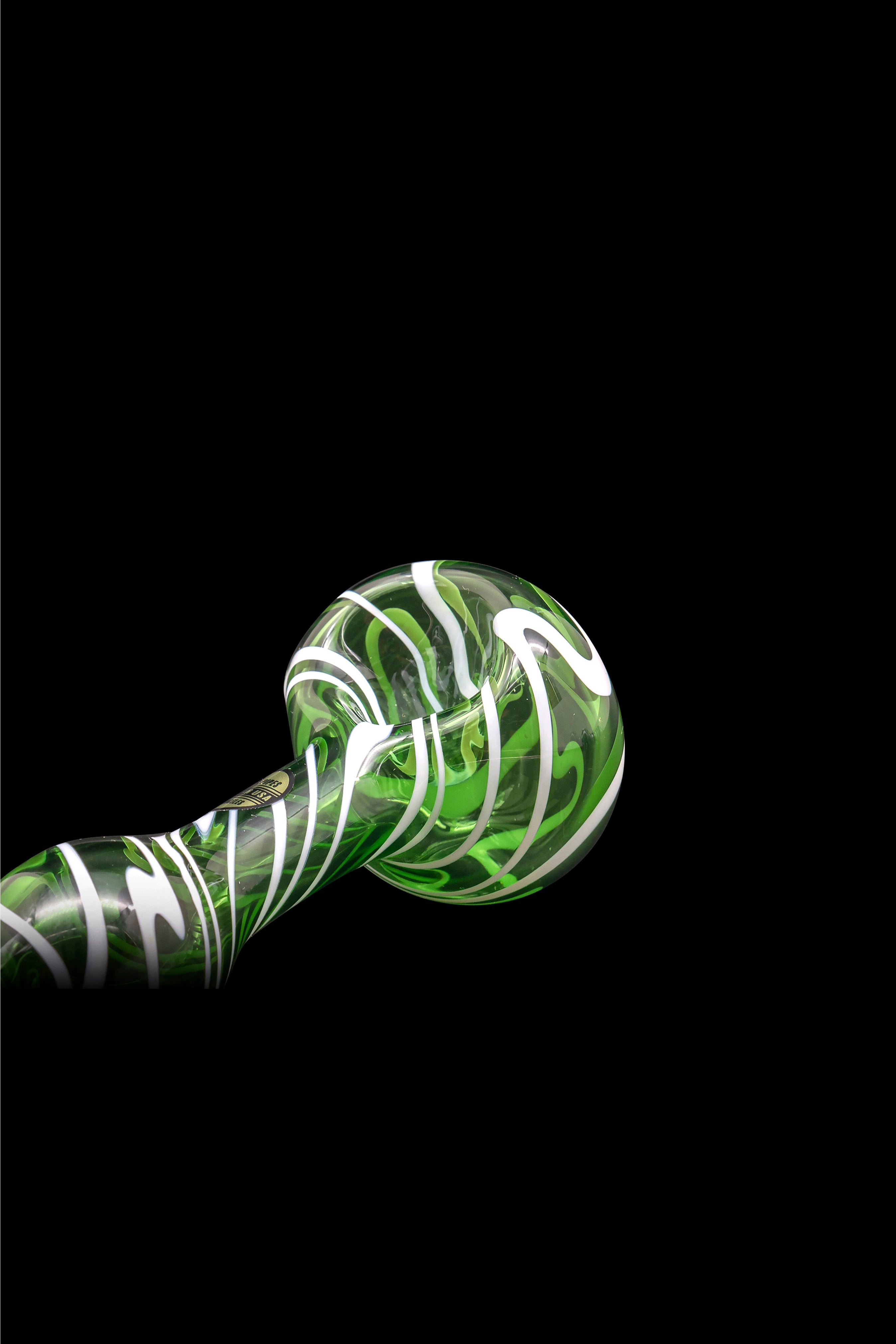 Green and white swirled glass pipe against a black background.