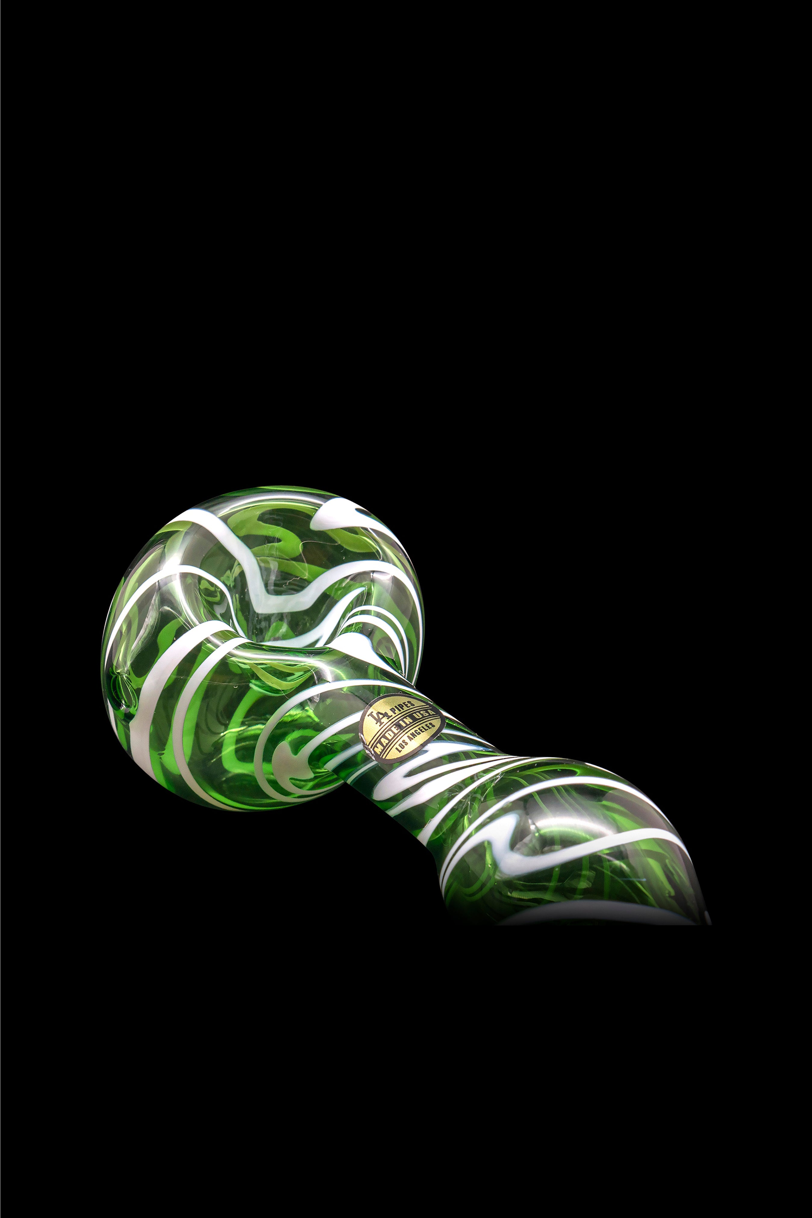 Green and white glass pipe against a black background.