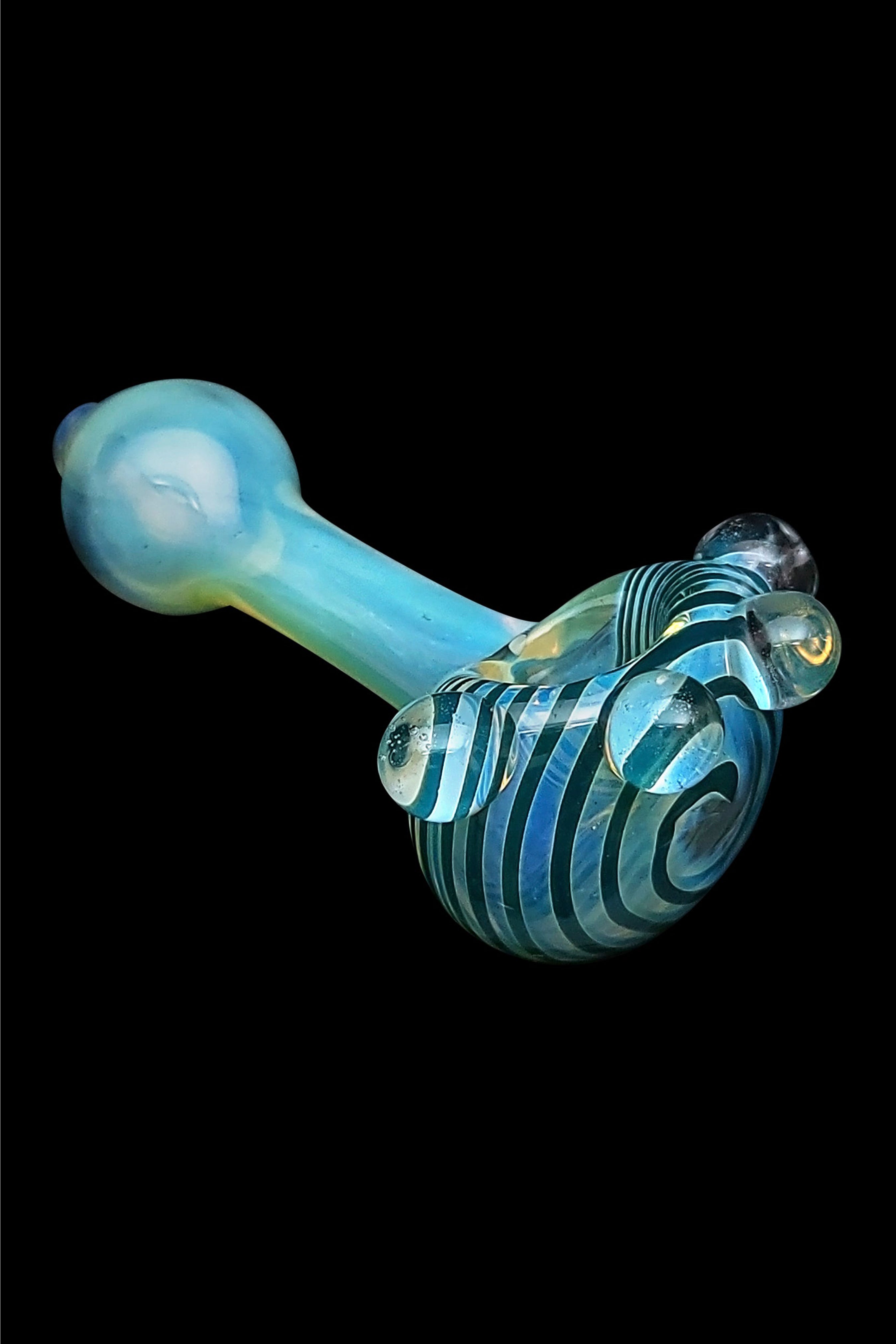 Blue glass pipe with swirling black and teal stripes, isolated on a black background.