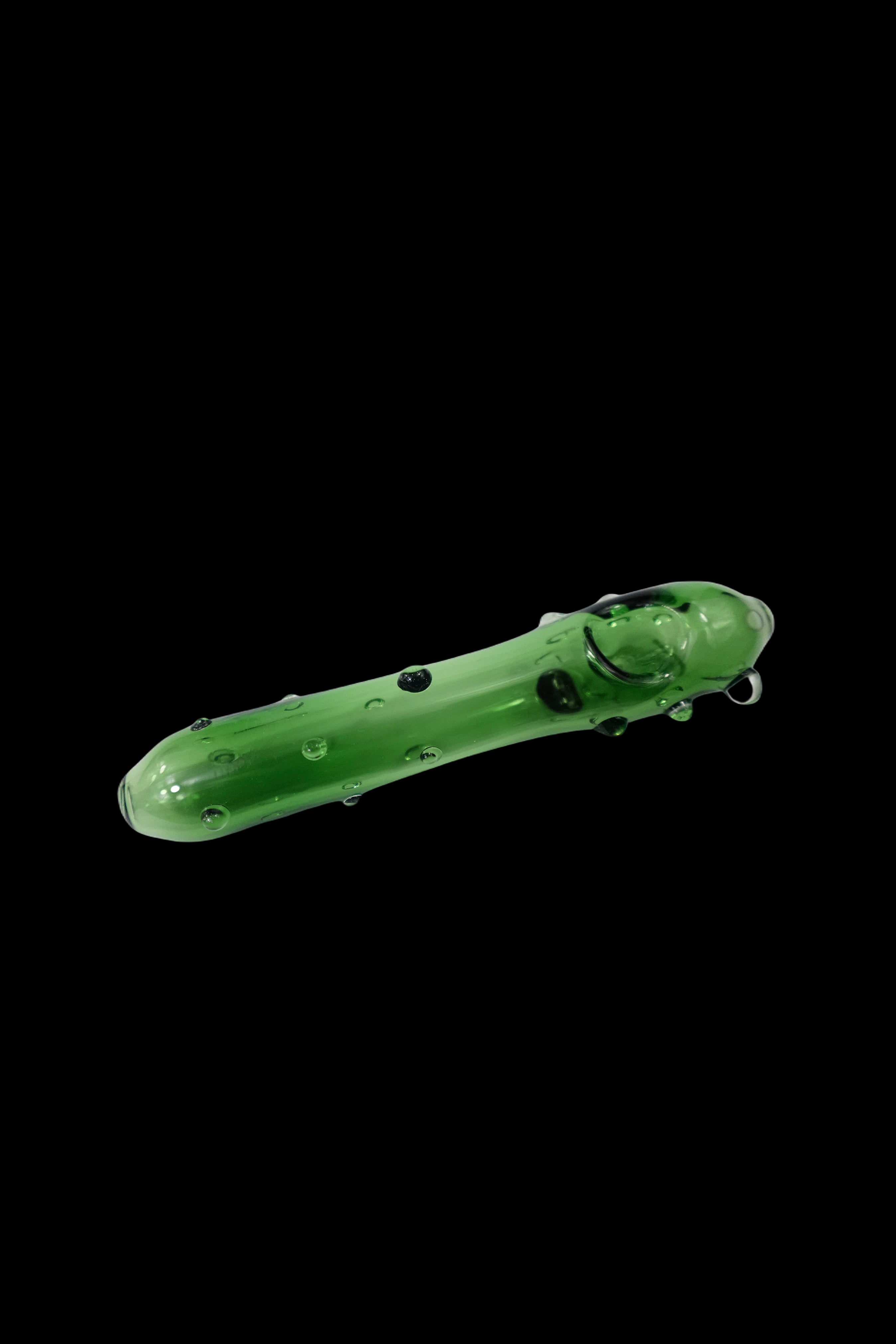 Green glass pipe resembling a pickle against a black background.