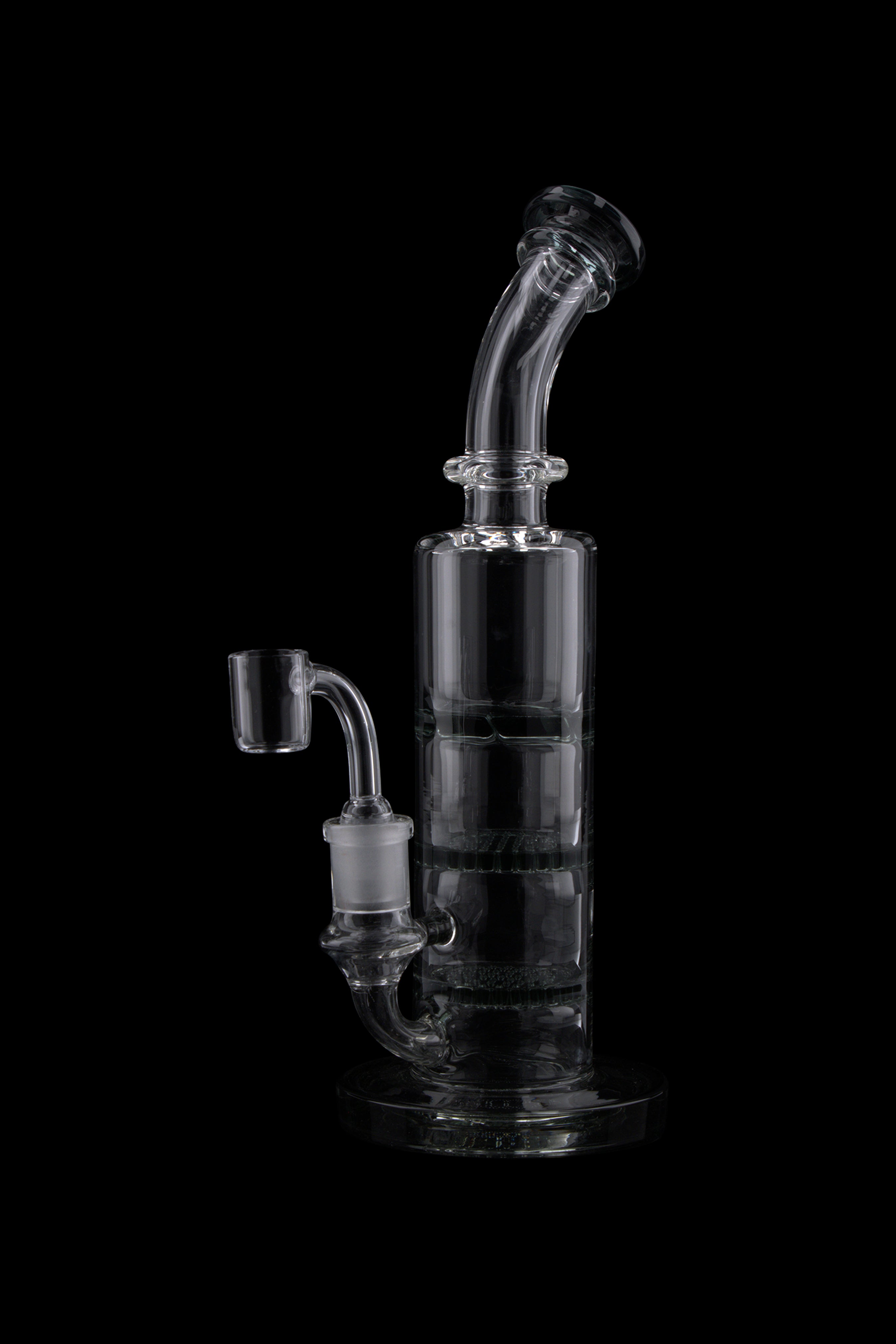 Angled close-up of the clear Triple Honeycomb Dab Rig showing its curved mouthpiece, stacked chamber and joint against a black background