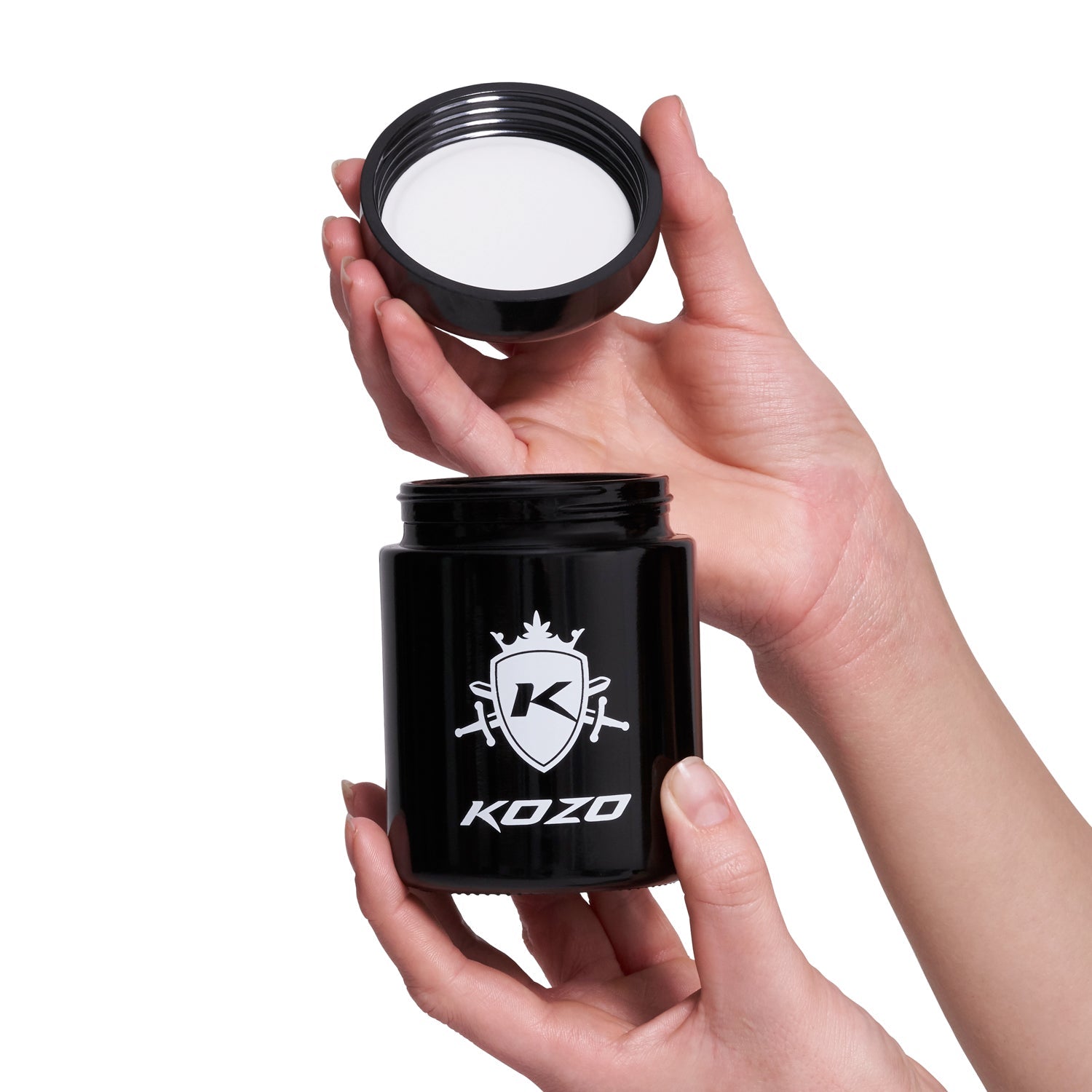 Hands holding an open black jar with a white crest logo and “KOZO” text, likely for cannabis storage.