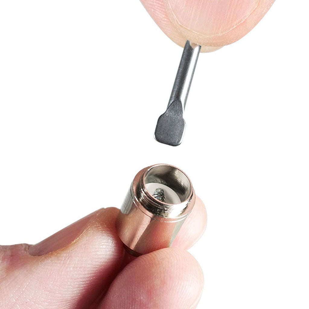 Close-up of fingers holding a small metal coil while a flat-tipped tool is poised above the RYOT® 3 Pack Of Extra Coils For 710 Wax Tank - New.