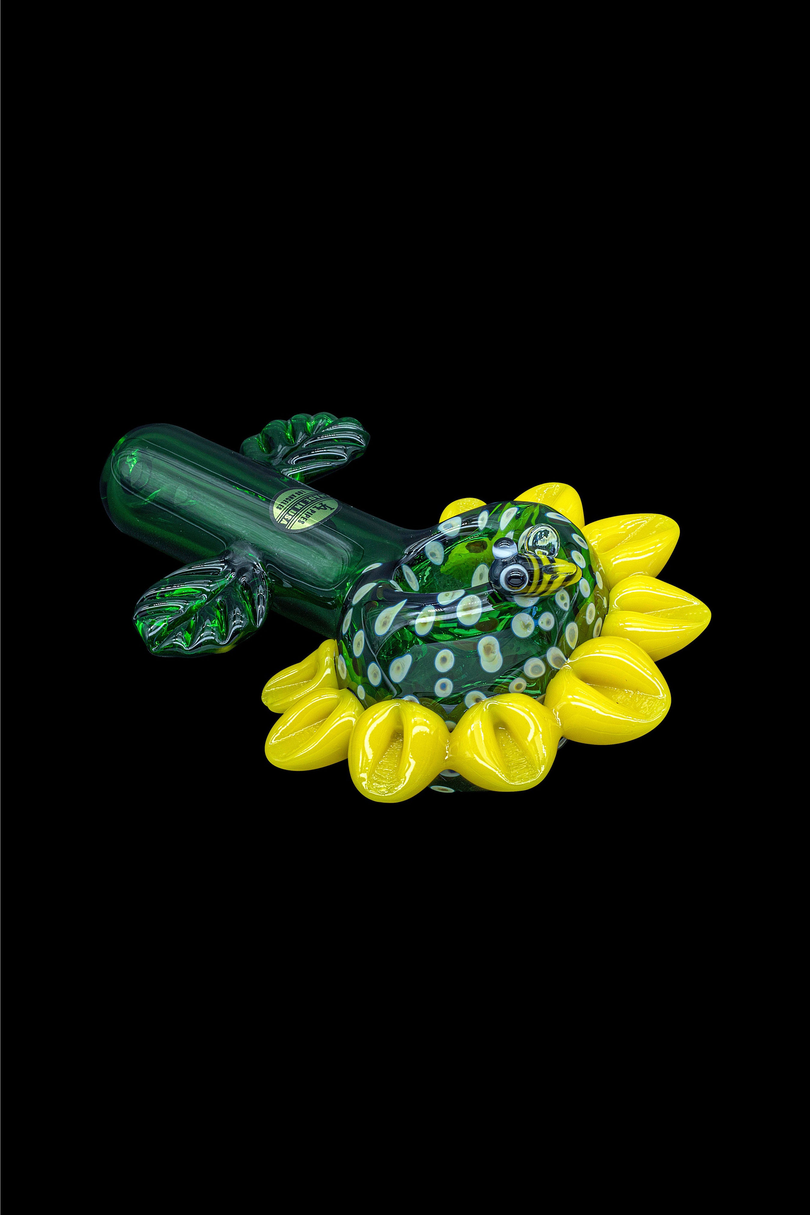 Green and yellow glass cannabis pipe shaped like a flower.
