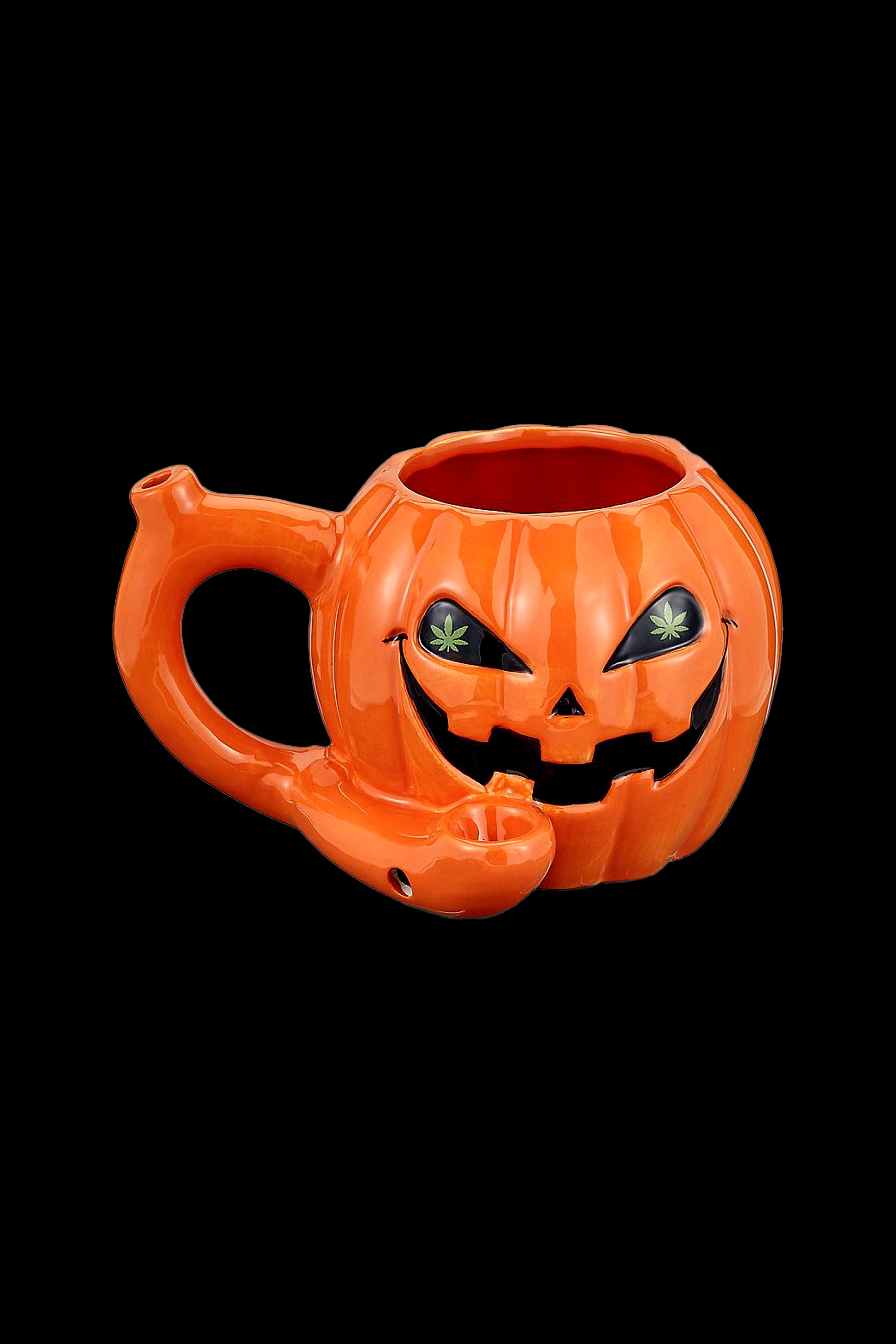 Orange jack-o'-lantern water pipe with cannabis leaf eyes.