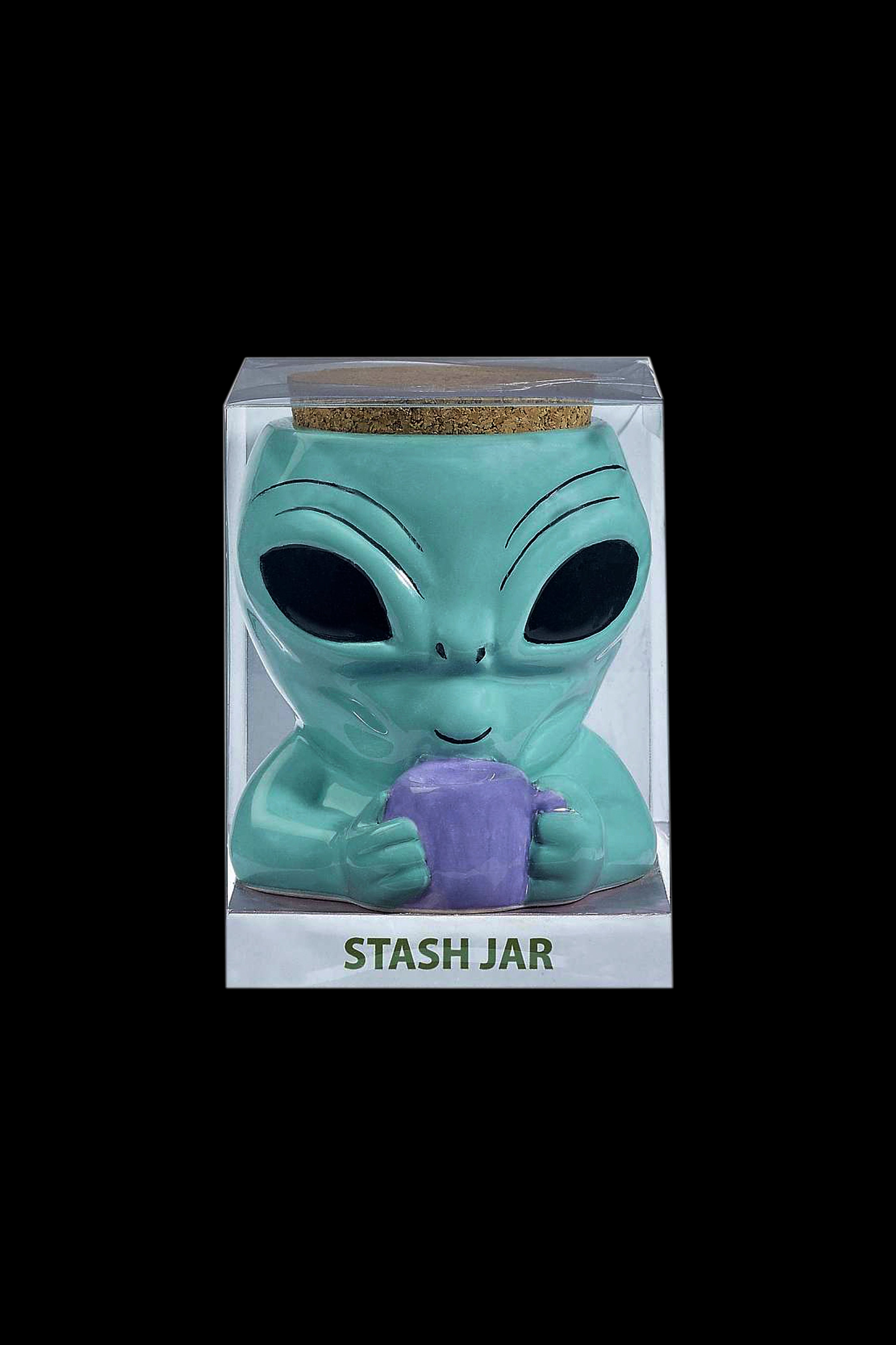 Green alien-shaped ceramic stash jar in clear packaging labeled “STASH JAR”.