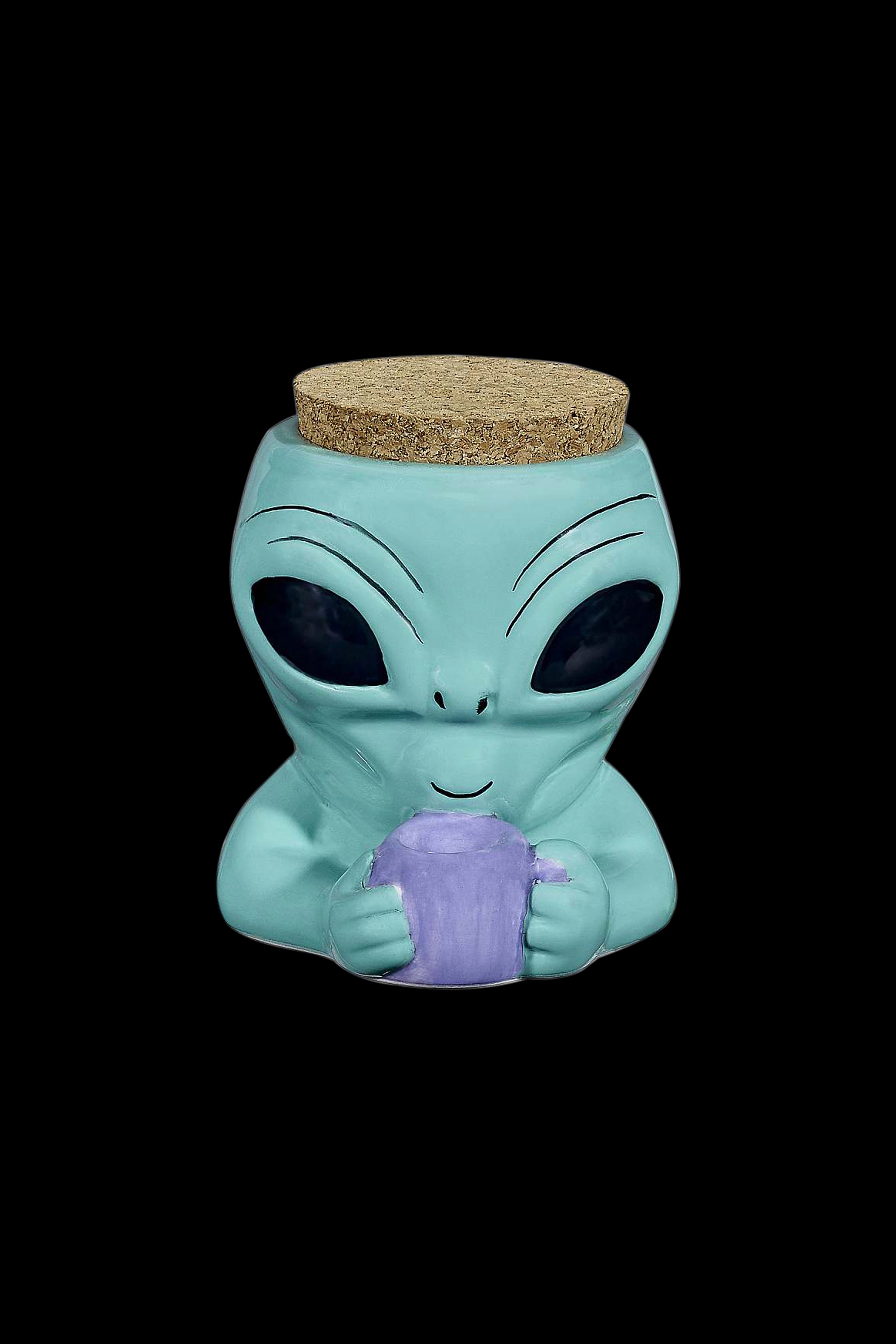 Turquoise alien-shaped ceramic jar with a cork lid, holding a purple crystalline object.