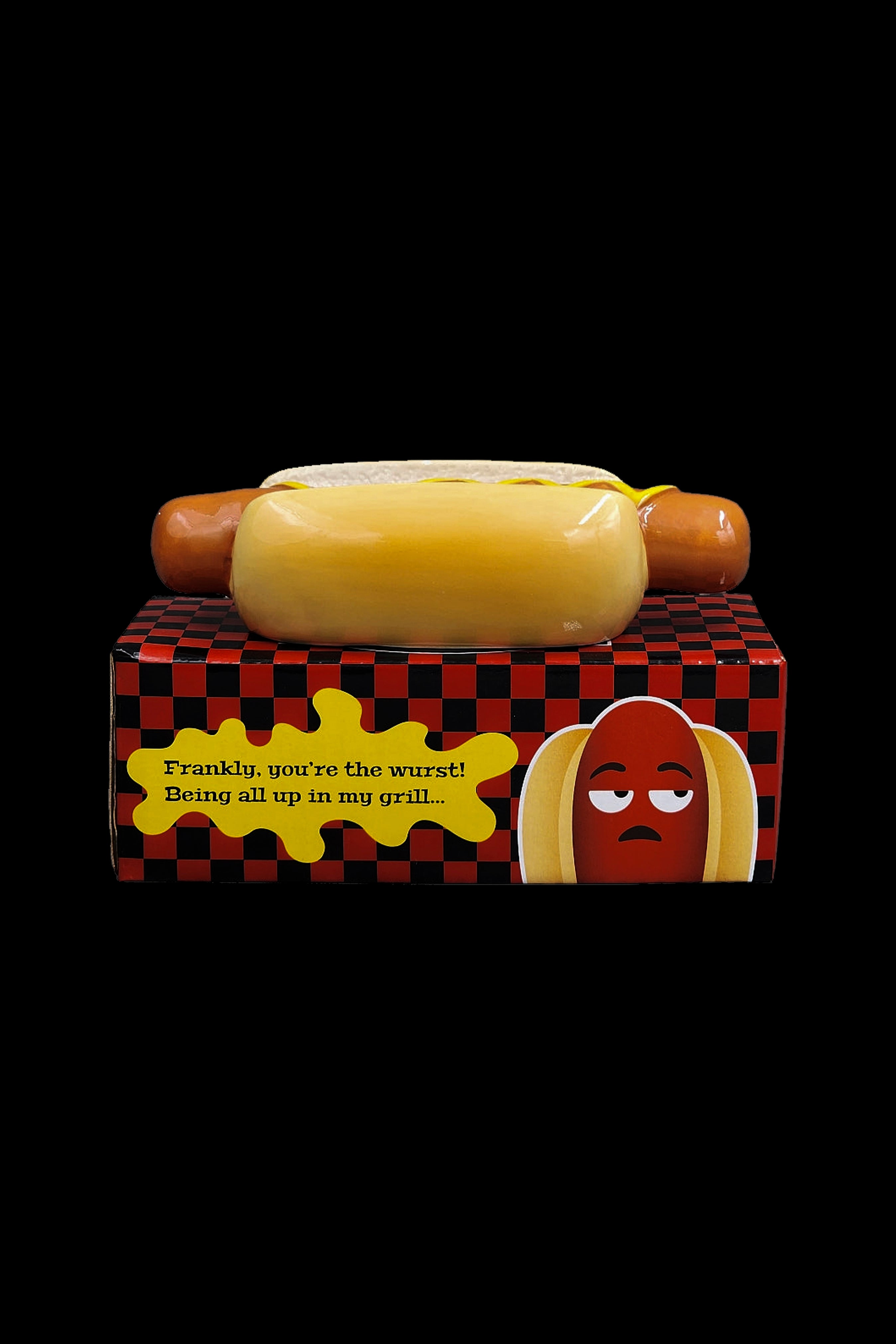 Hot dog-shaped cannabis grinder with text reading "Frankly, you're the wurst! Being all up in my grill..." on a patterned box.