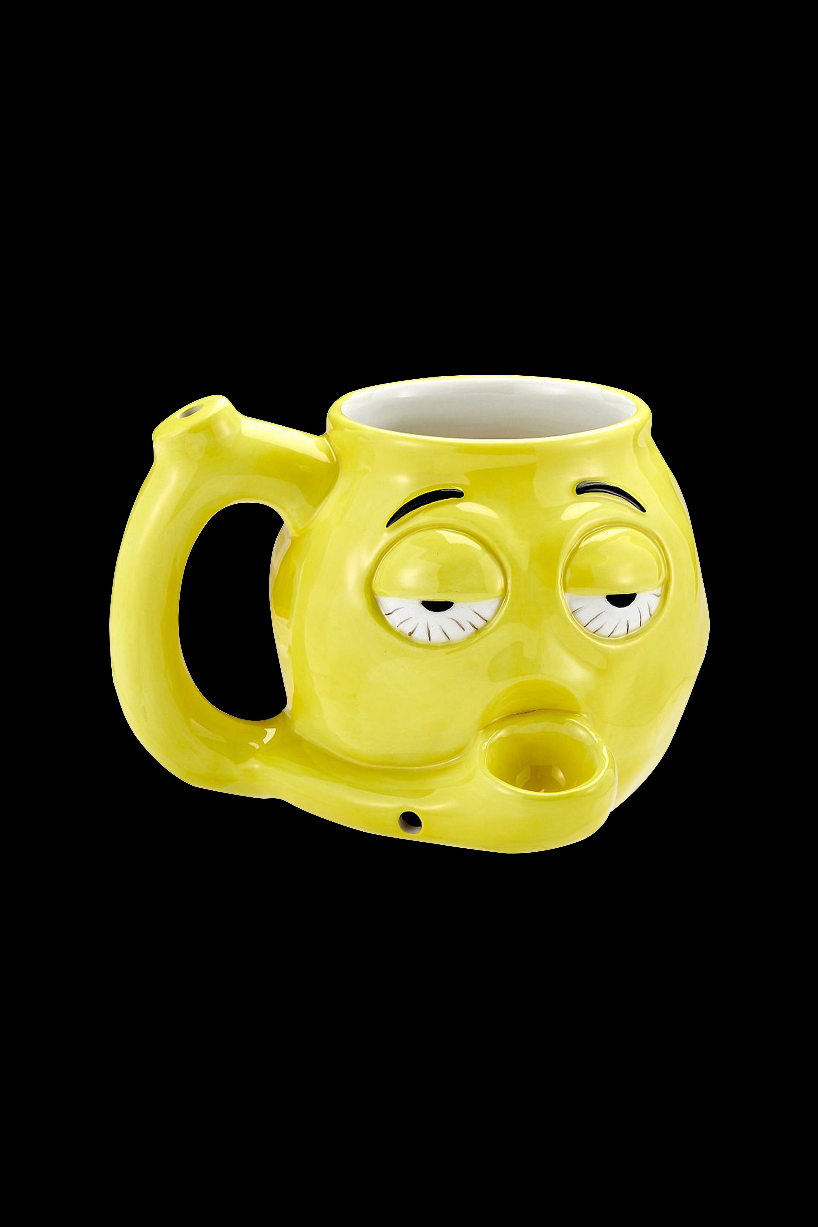 Yellow ceramic smoking piece shaped like a cartoon face with closed eyes and a protruding mouthpiece.