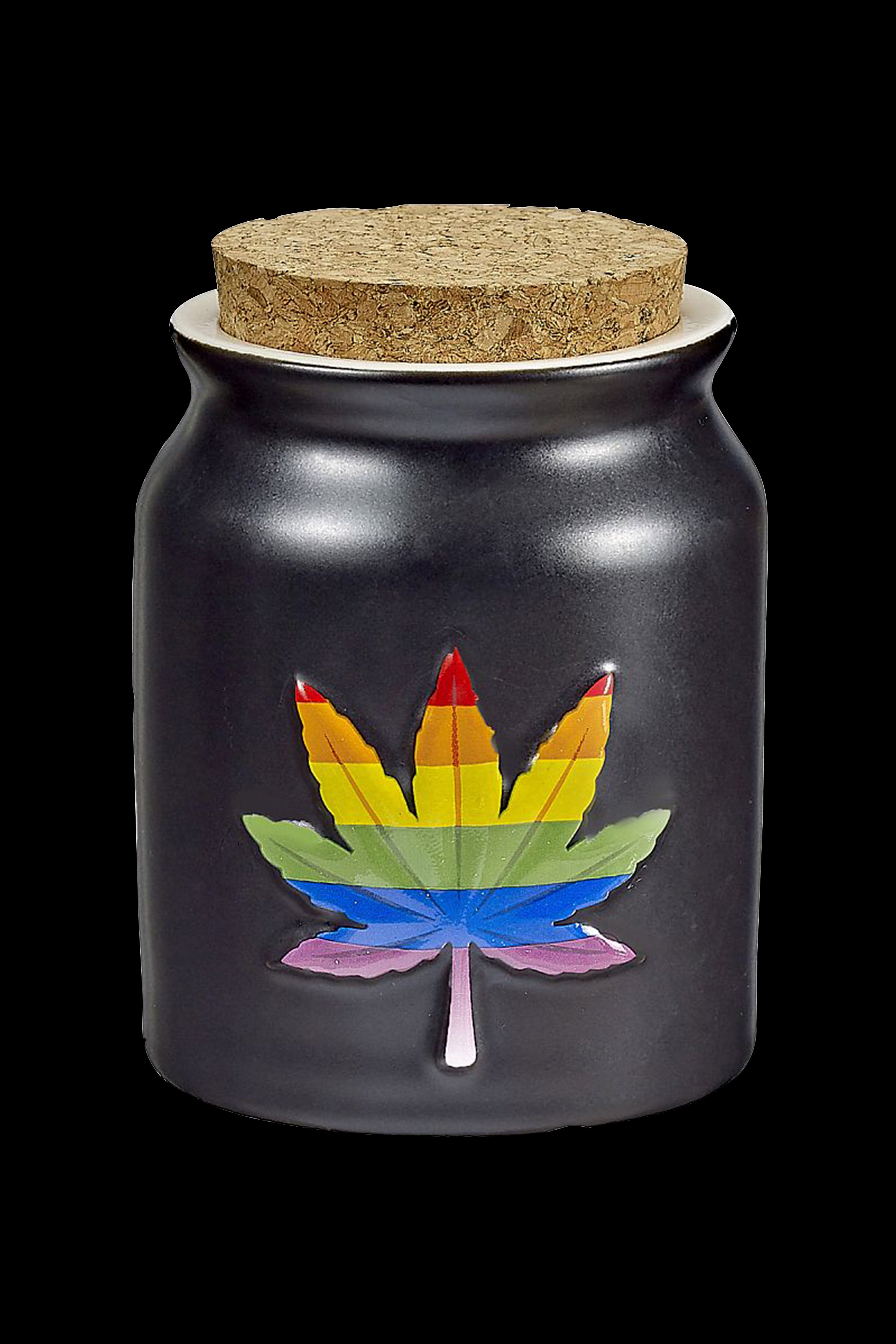 Black glass jar with a rainbow cannabis leaf emblem and cork lid.