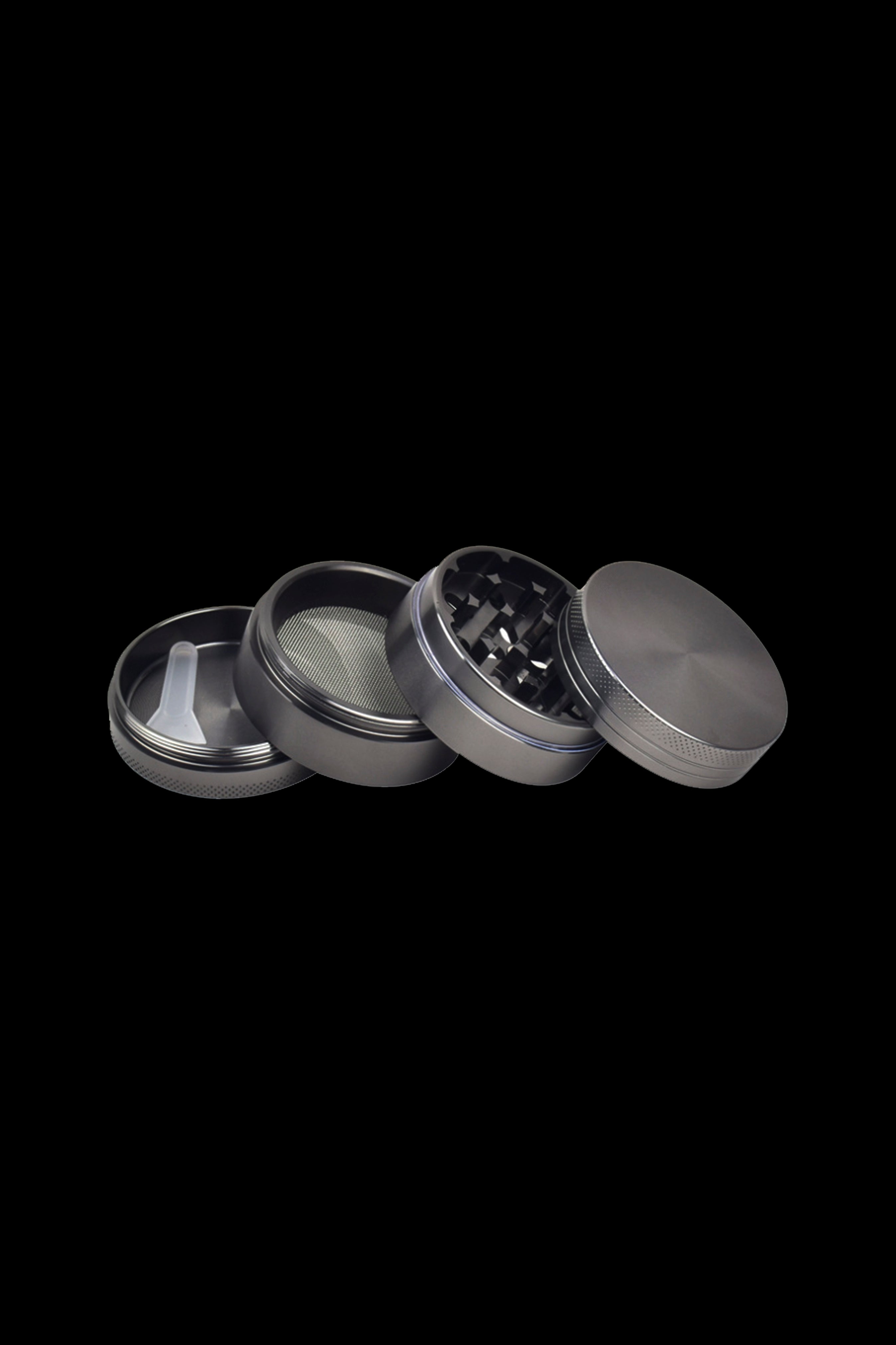 Black four-piece cannabis grinder disassembled on a black background.