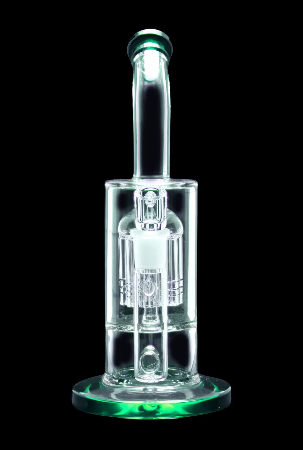 Glowing green glass dab rig against a black background.