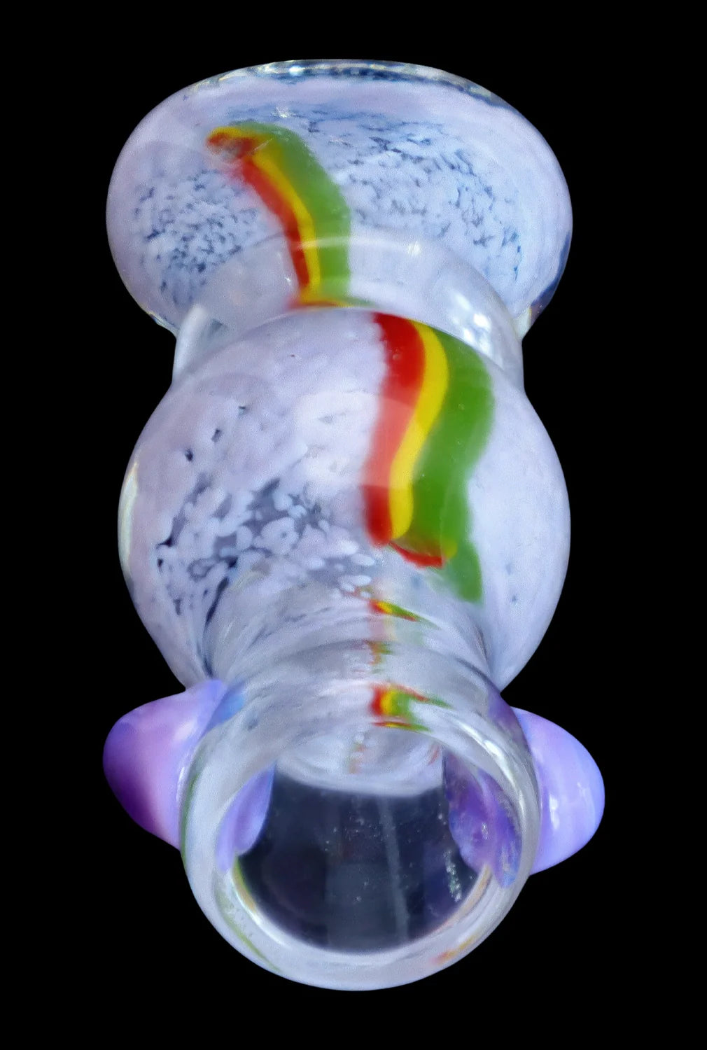 Top-down close-up of the Smoke Cartel Frit Rasta One Hitter - 3 in. showing its white fritted glass body with a central red-yellow-green rasta stripe and purple glass accents.