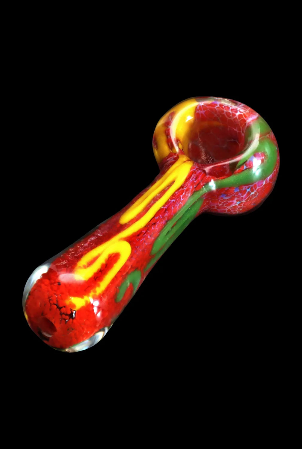 Angled close-up of the Smoke Cartel Color Frit Spoon Pipe - 3 in., showing a red glass bowl and stem with yellow and green swirls against a black background