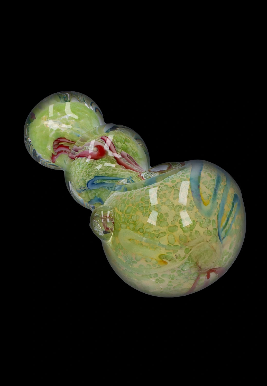 Angled close-up of the Smoke Cartel Fancy Frit Spoon Pipe - 3.5 in. showing green frit patterns, swirled blue accents, and glossy reflections on a black background