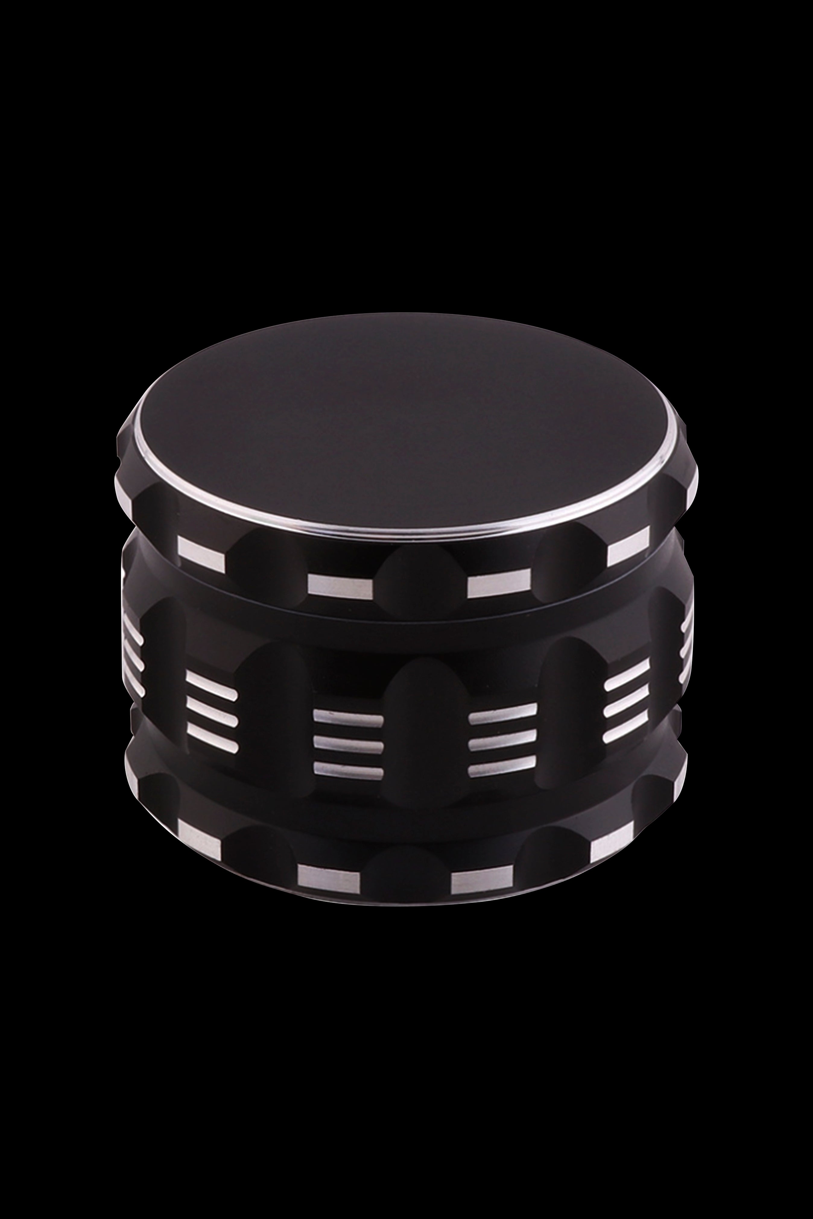 Black metal cannabis grinder with silver accents, isolated on a black background.
