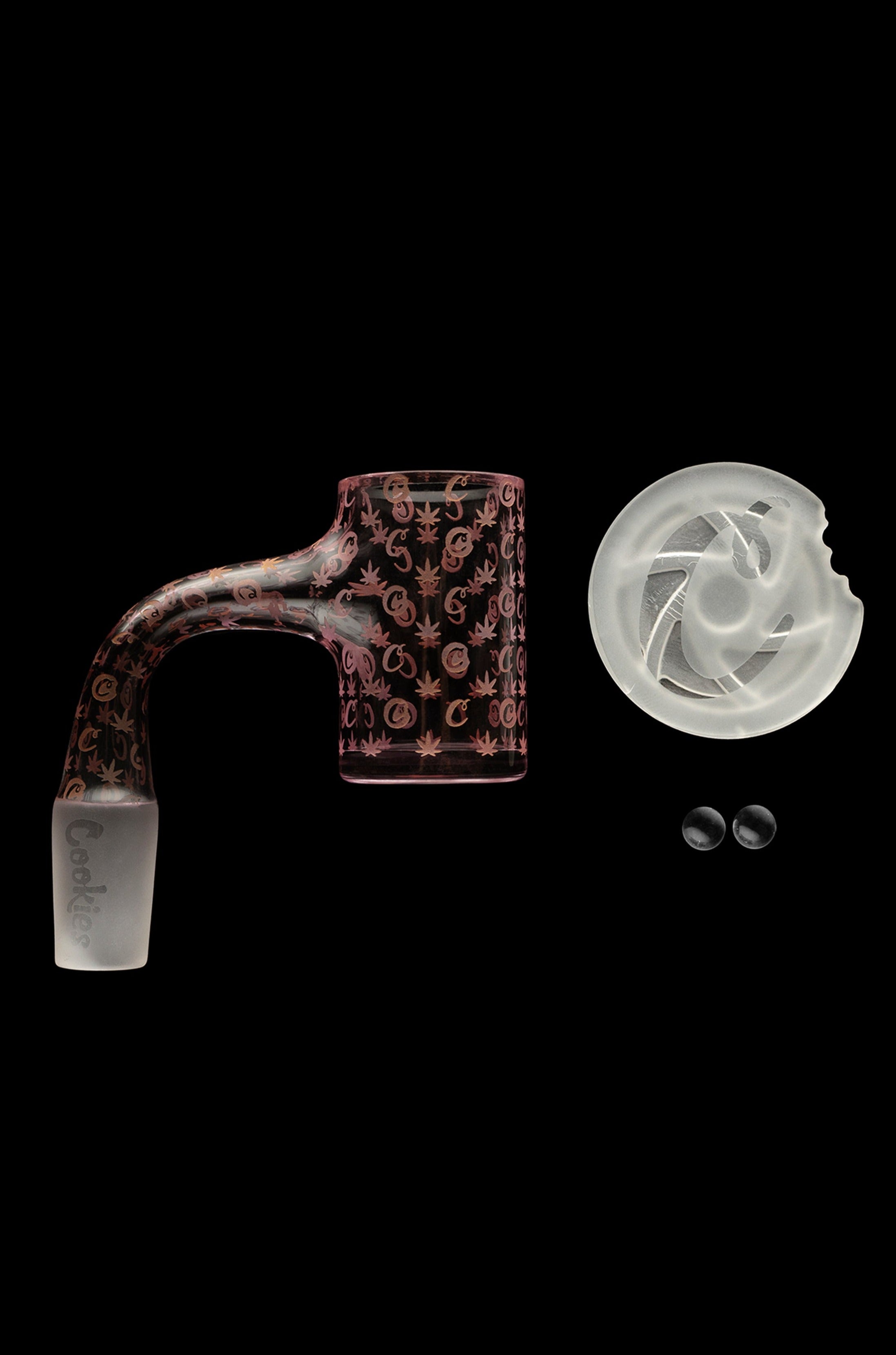 Red cannabis oil rig attachment with marijuana leaf pattern, a quartz insert, and two small silicone caps on a black background.