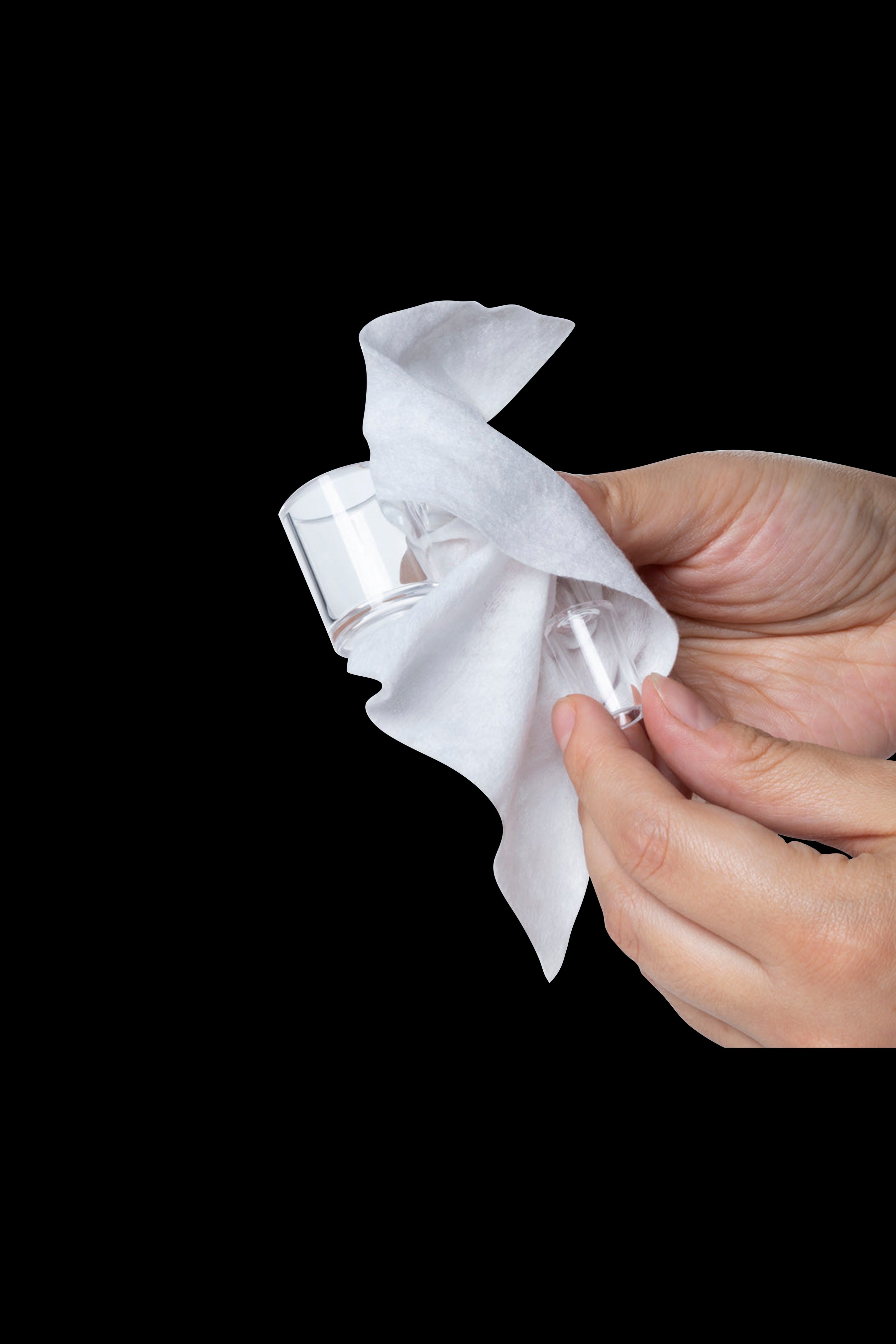 Hand holding a cannabis filter tip wrapped in white tissue paper.