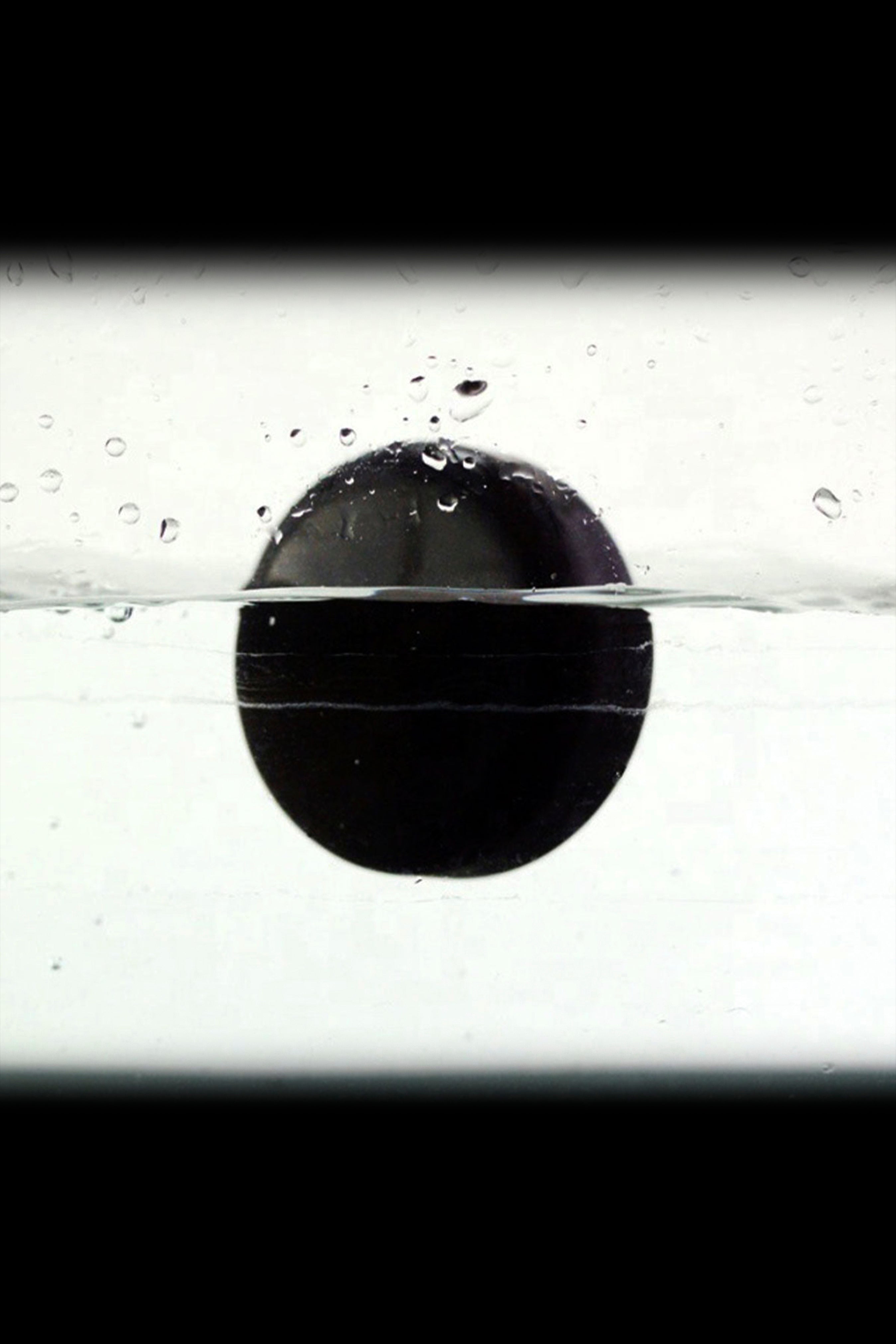 Black cannabis bubble partially submerged in water, creating a striking visual.