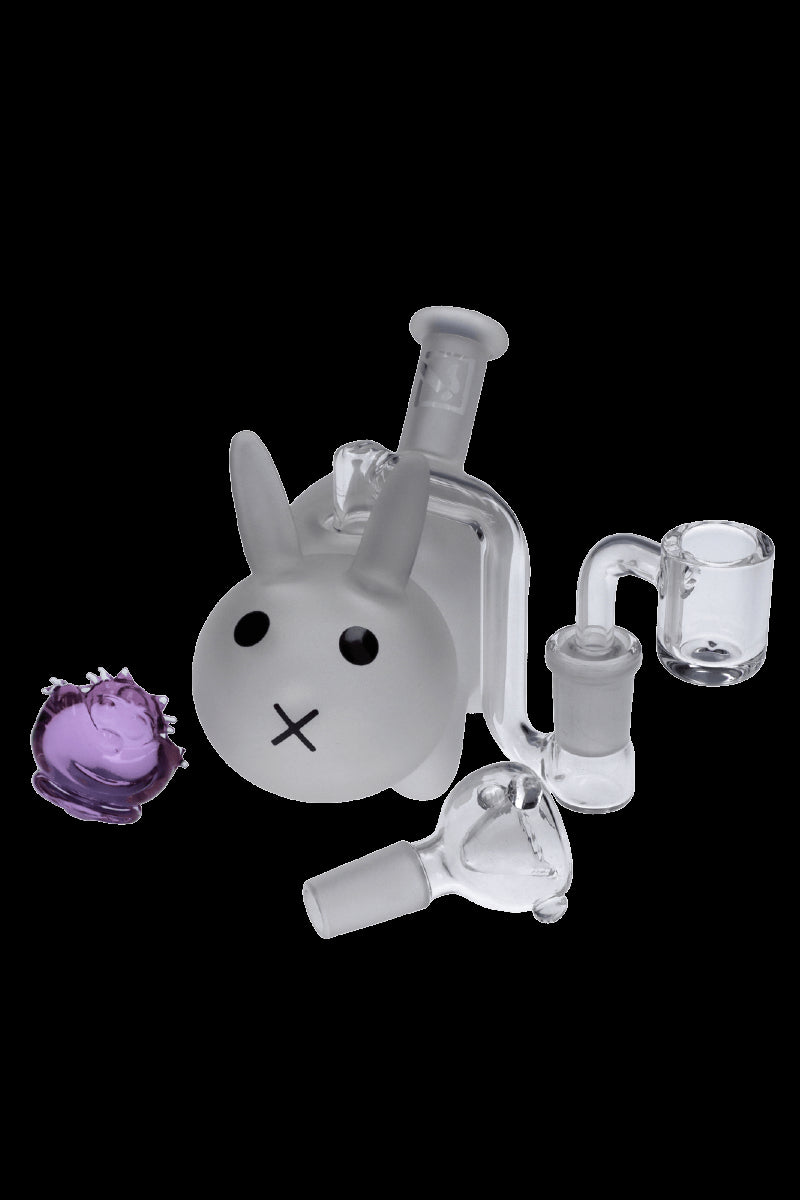 Glass water pipe shaped like a bunny with accompanying glass pieces and cannabis bud.