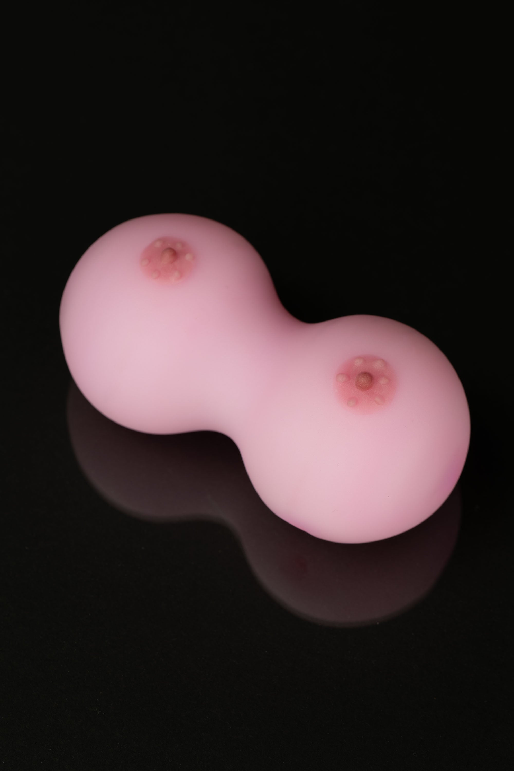 Pink silicone cannabis concentrate container with two circular chambers.