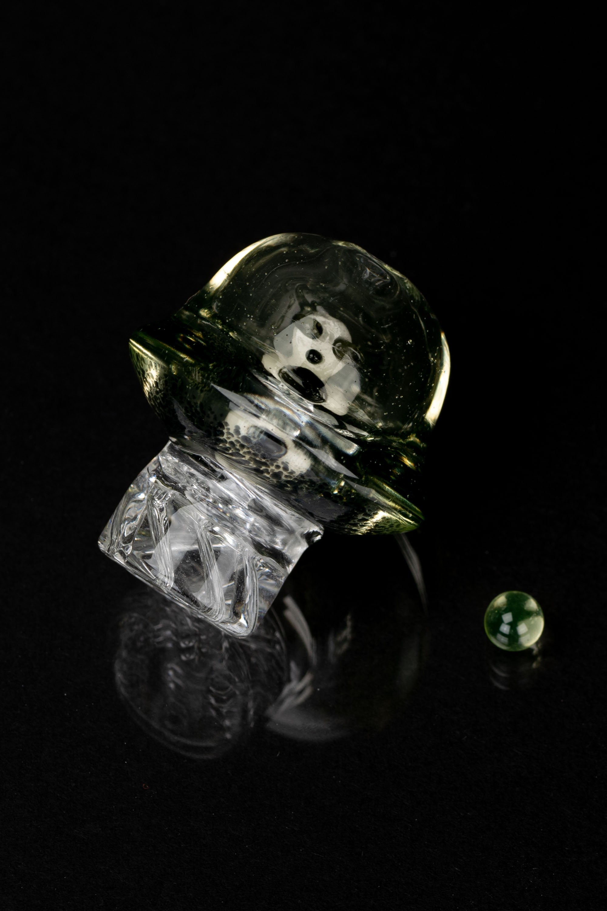 Abstract studio shot of a glass cannabis water pipe against a black background.