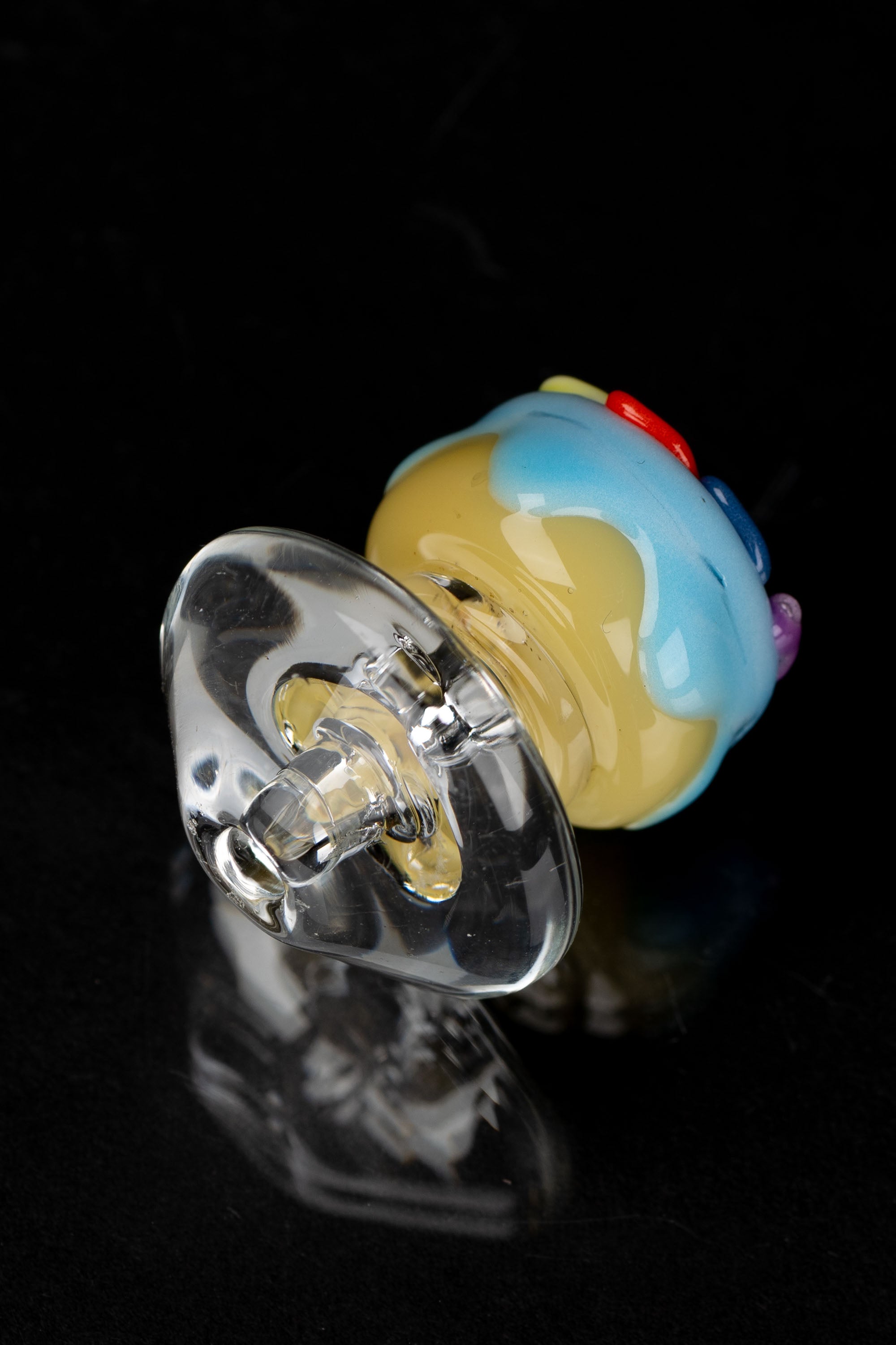 Hand-blown glass cap with colorful accents, likely for use with cannabis concentrates.