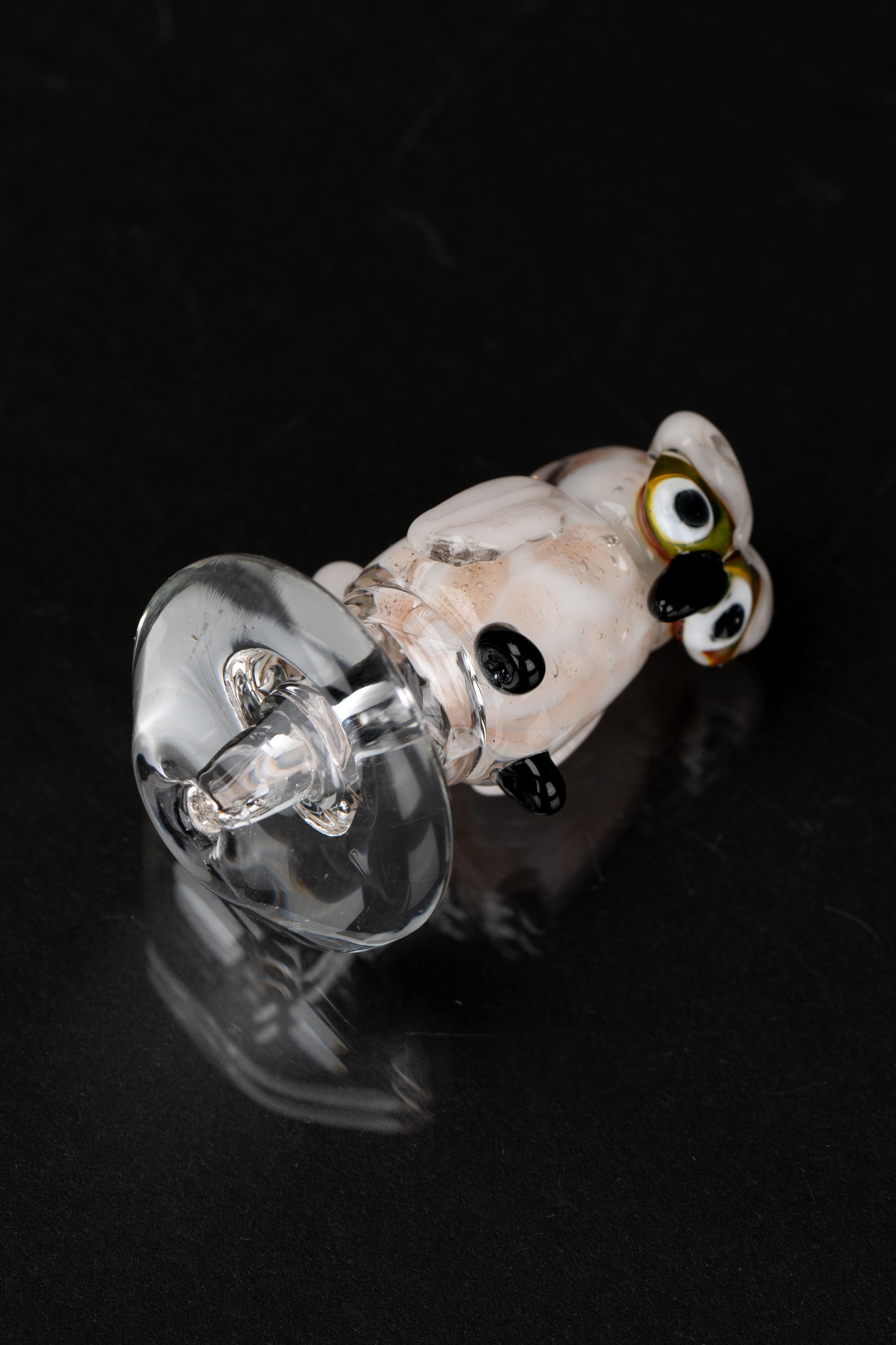 Glass cannabis oil burner pipe with colorful accents, isolated on black.