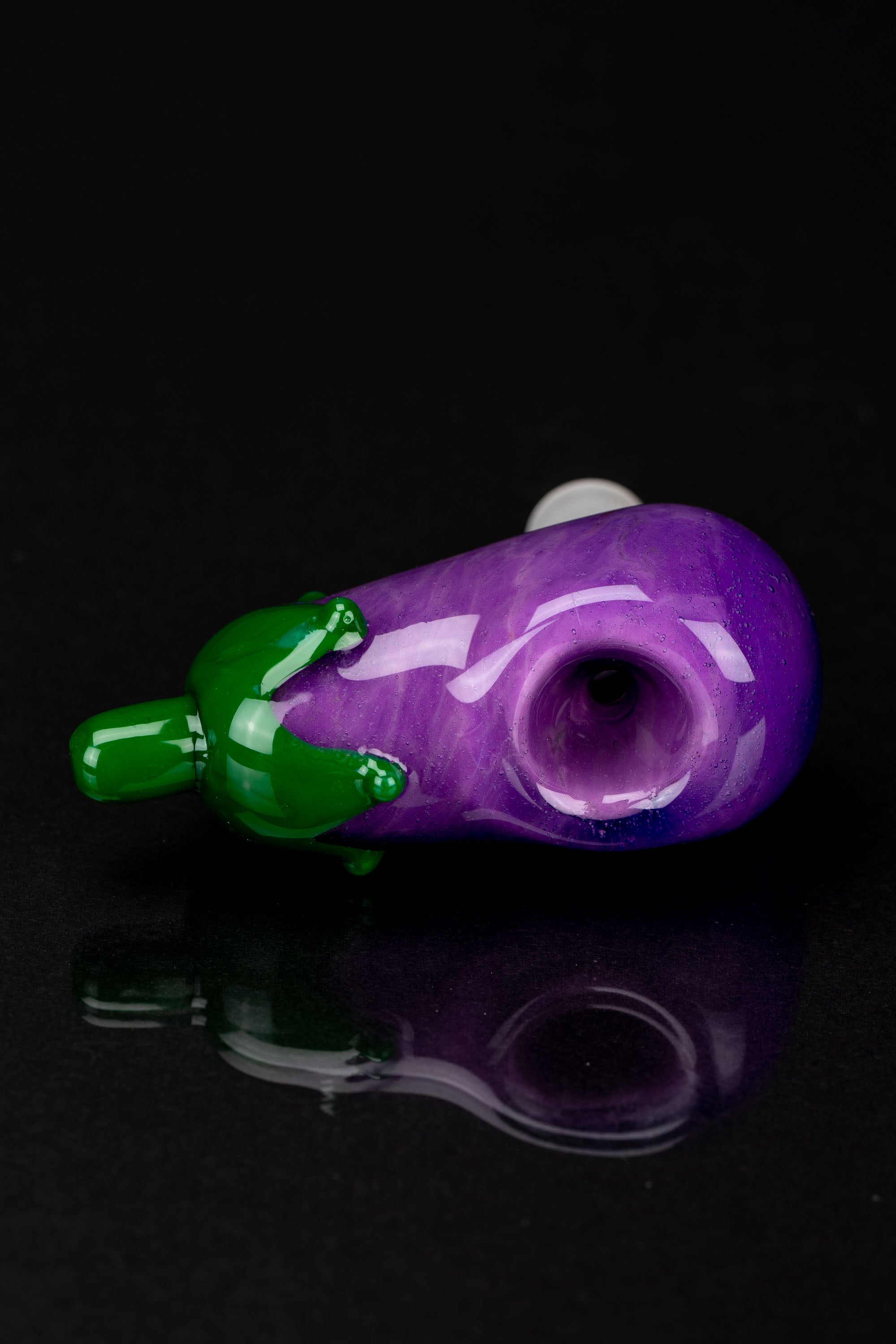 Purple glass pipe with green accents, studio shot.