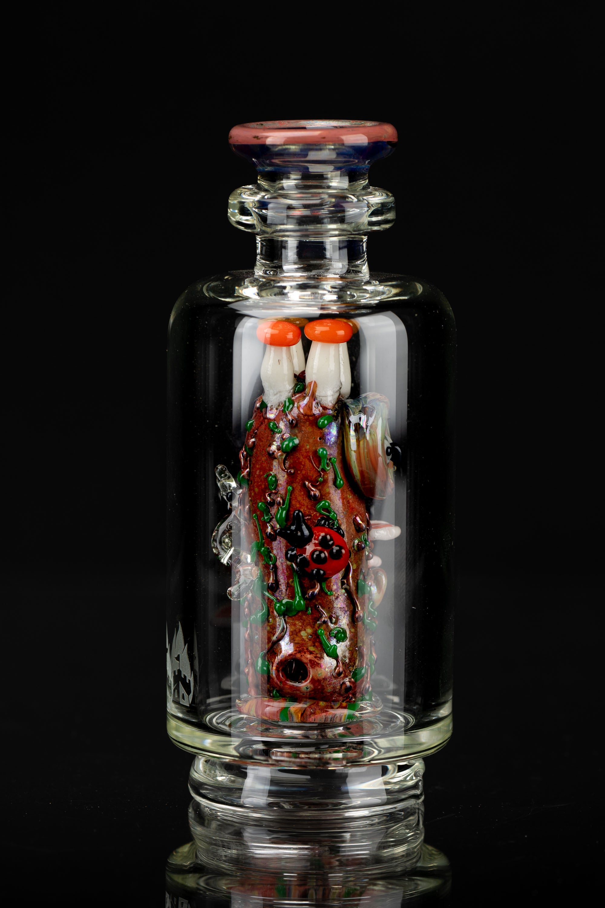 Intricate glass cannabis water pipe featuring a red and green sculpted design resembling a brain, set against a black background.
