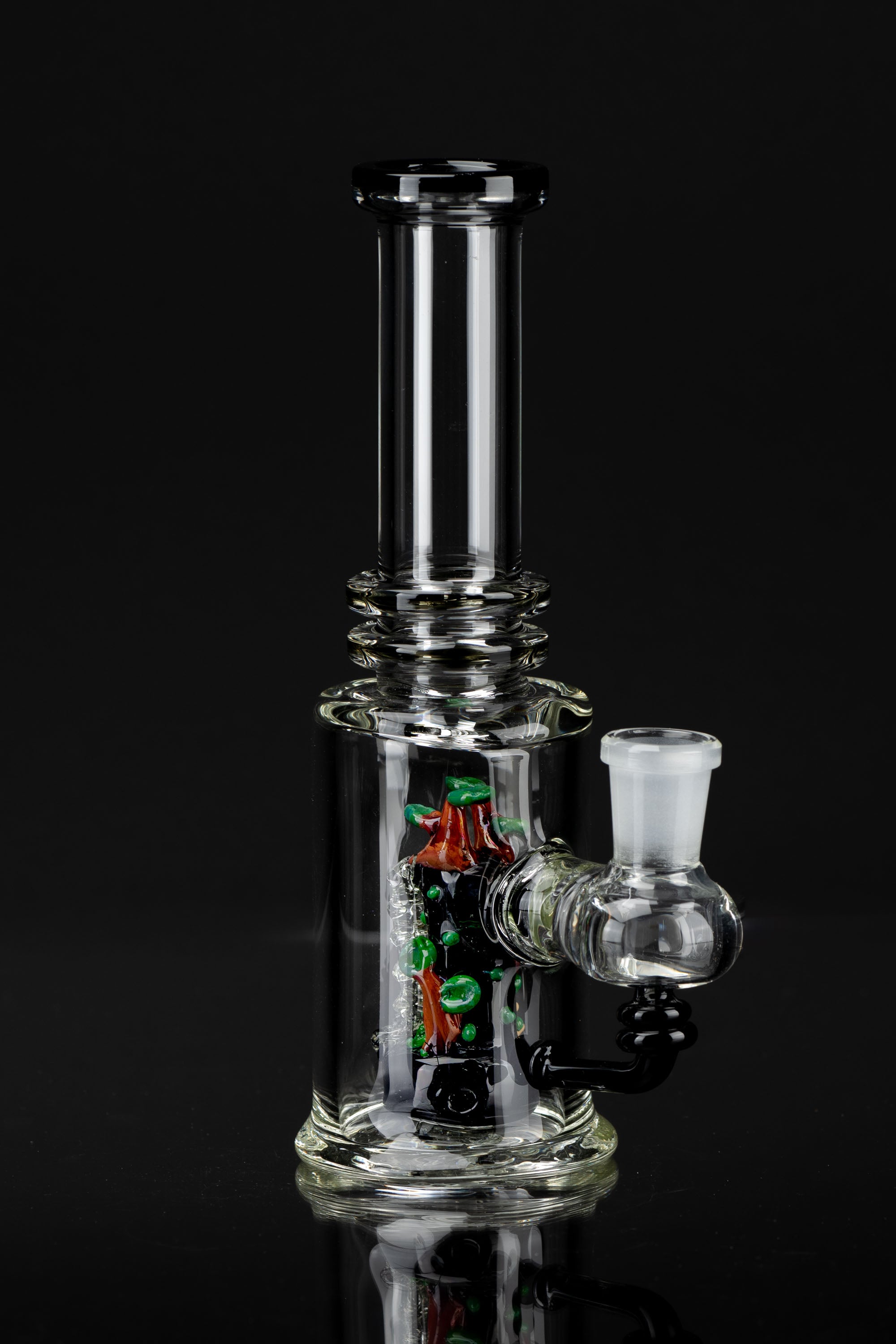 Clear glass water pipe (bong) with colorful glass accents, studio shot on black.