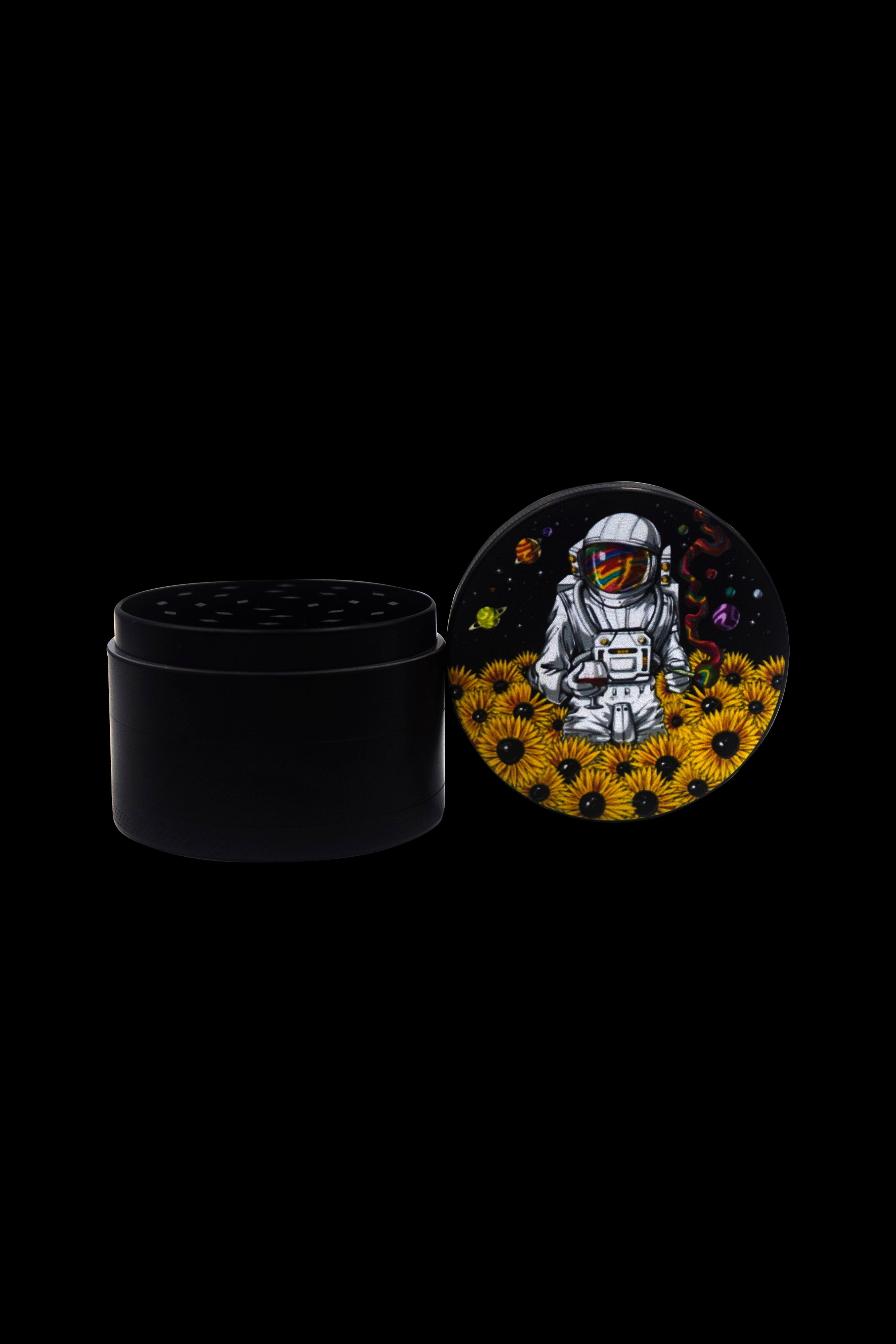 Black grinder with a lid displaying an astronaut amongst sunflowers and planets, cannabis-themed art.