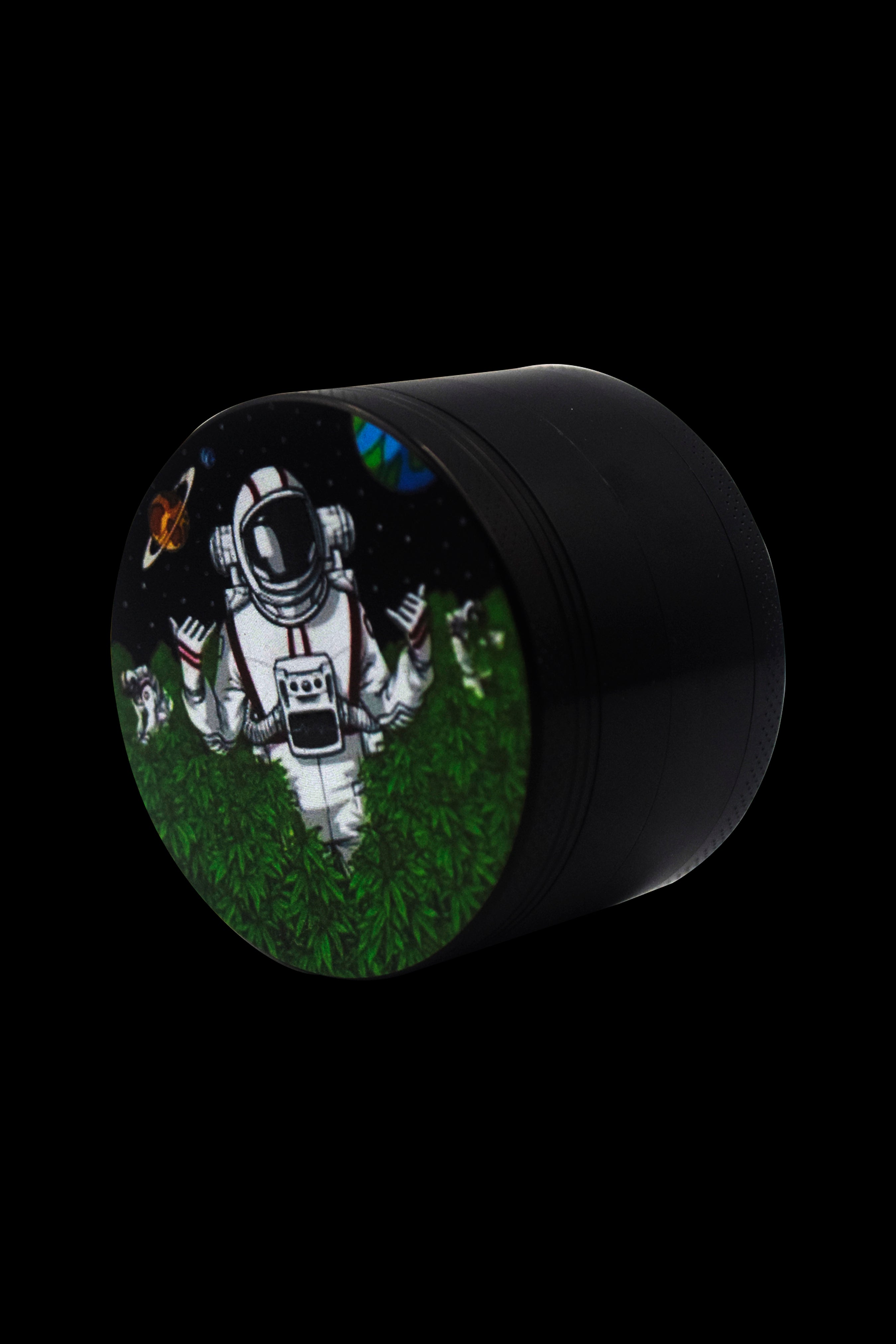 A black grinder with a circular art insert depicting an astronaut sitting in a field of cannabis leaves.