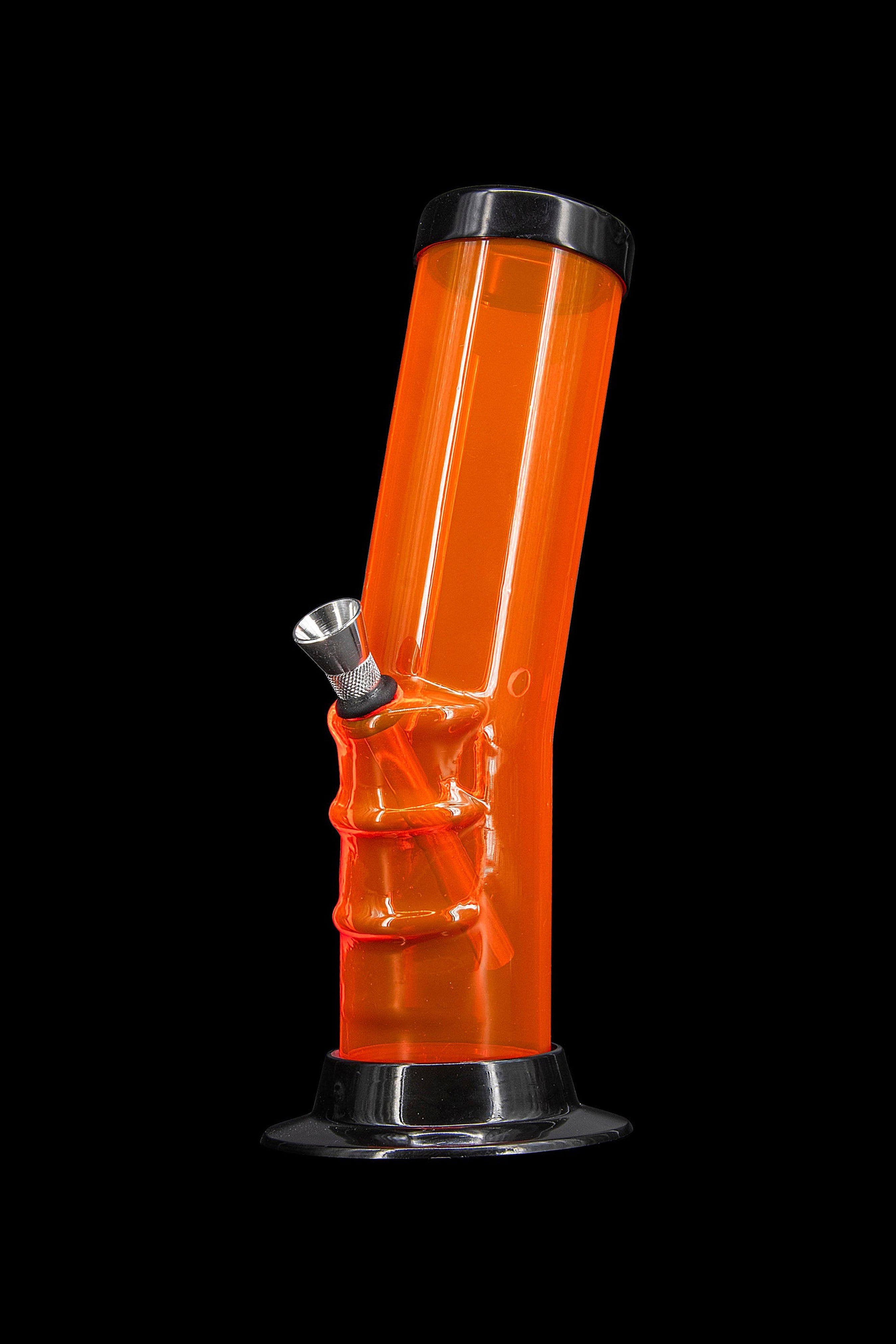 Orange glass water pipe against a black background.
