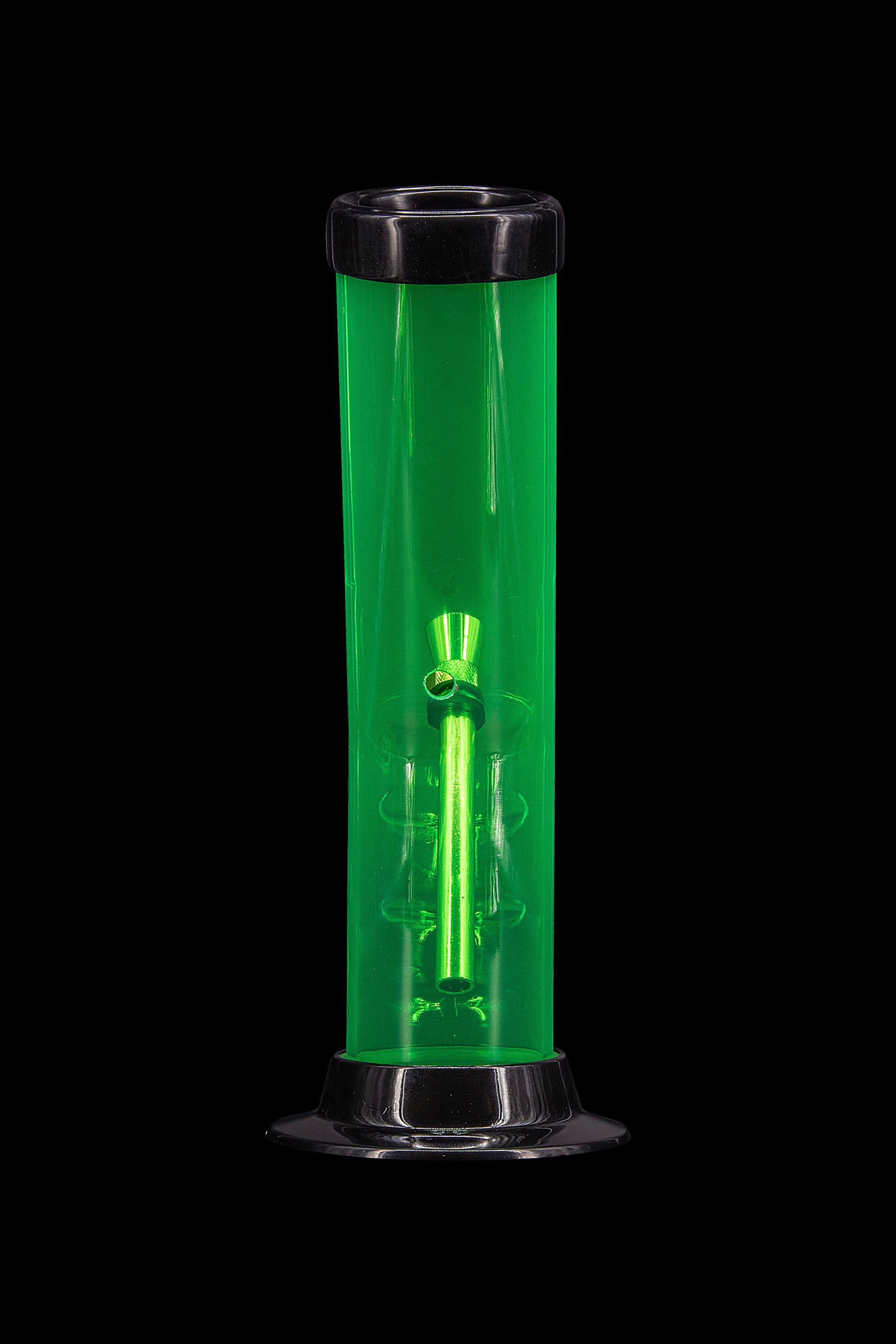 Green glass bong with intricate design, isolated on a black background.