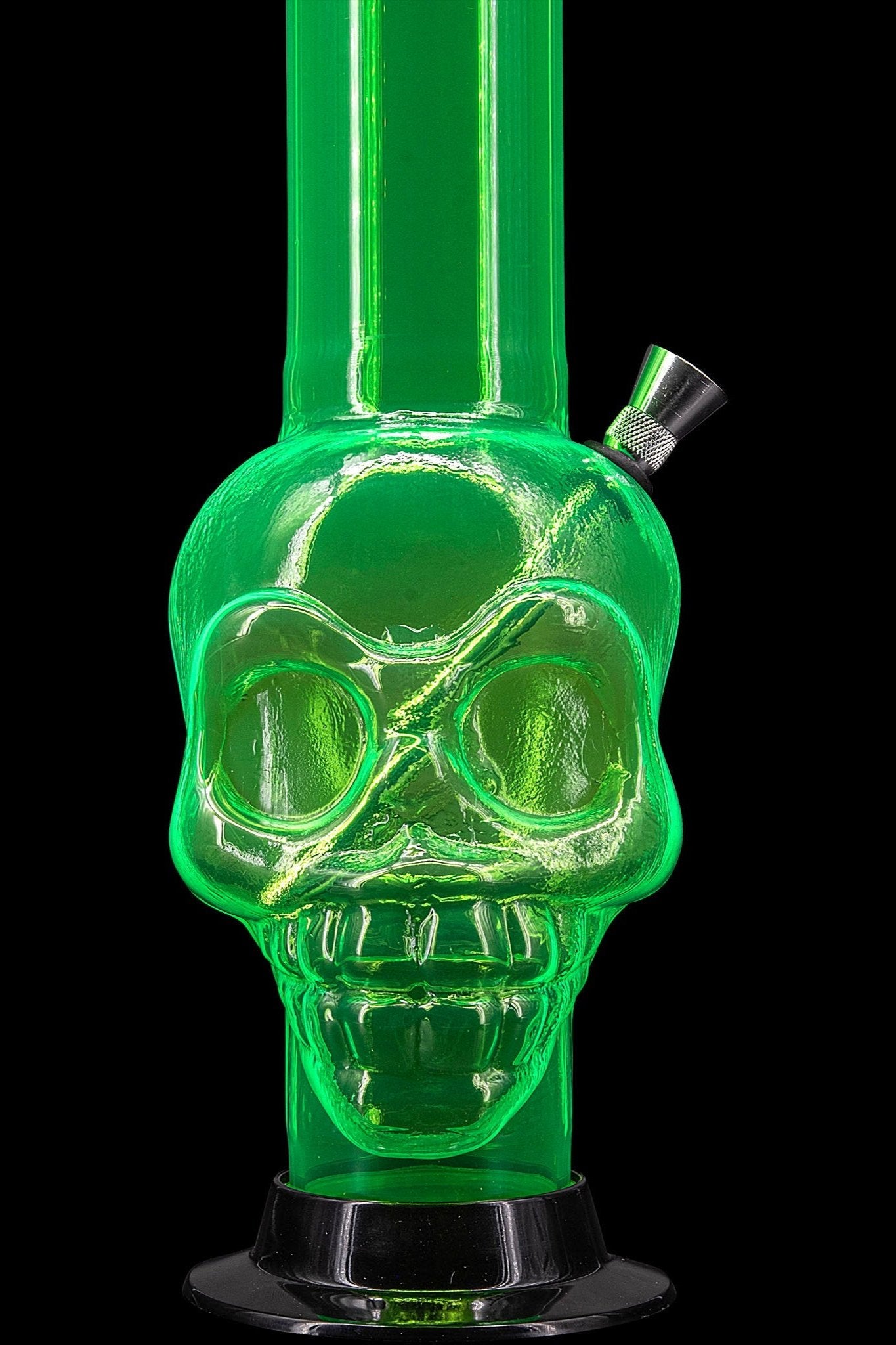 Green glass skull-shaped bong against a black background.