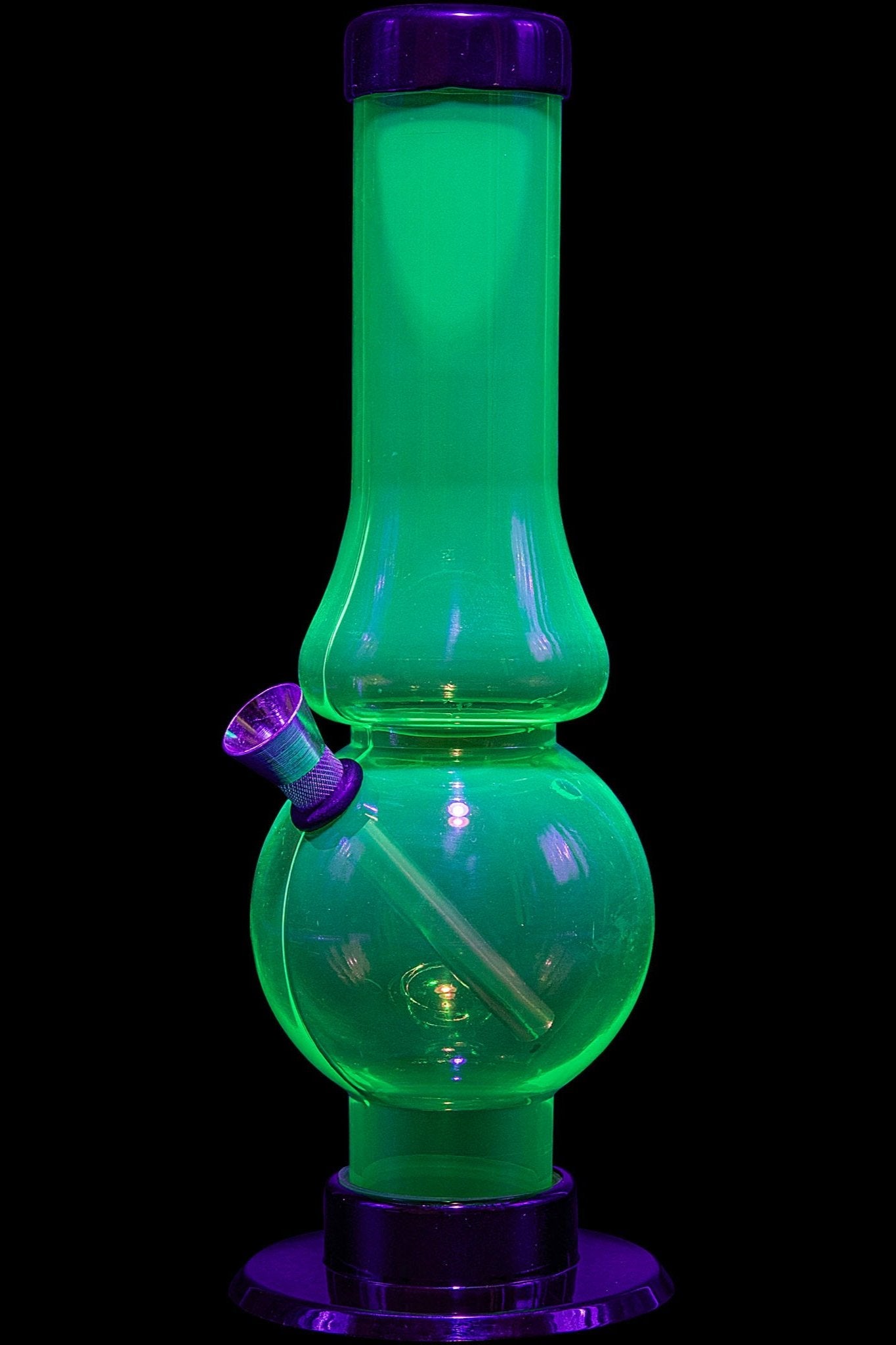 Glowing green glass water pipe (bong) against a black background.