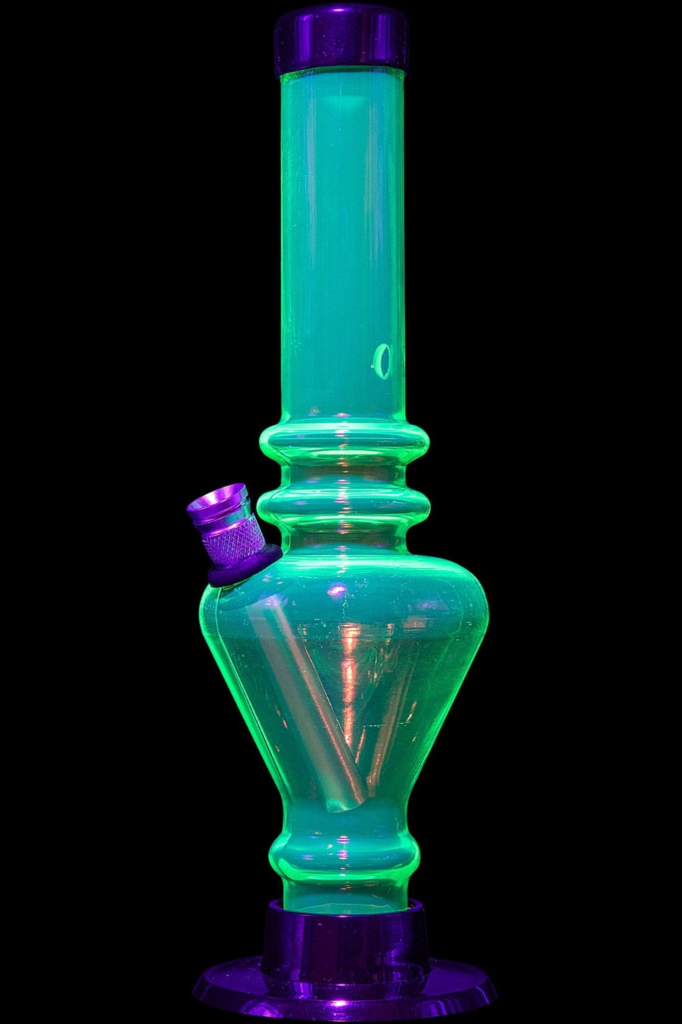 Glowing green glass water pipe with purple accents, isolated on black.