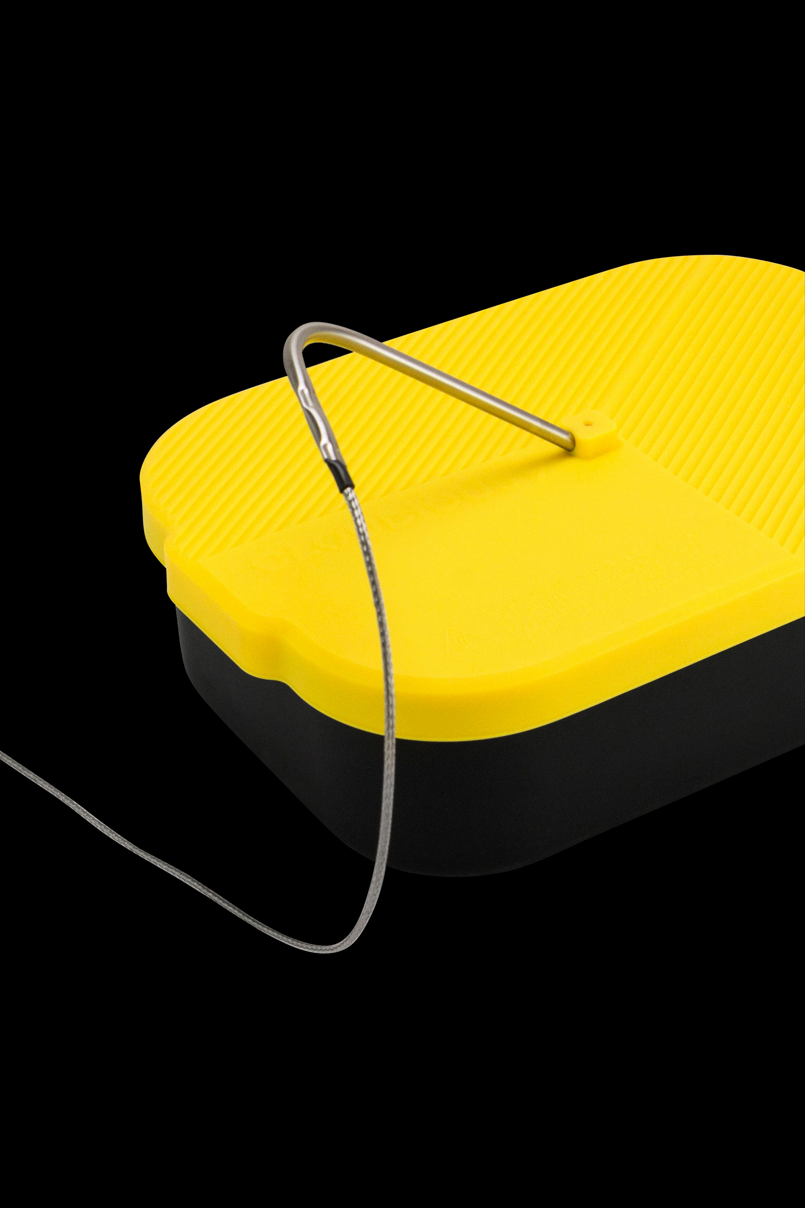 Yellow and black silicone container with a dab tool resting on top.
