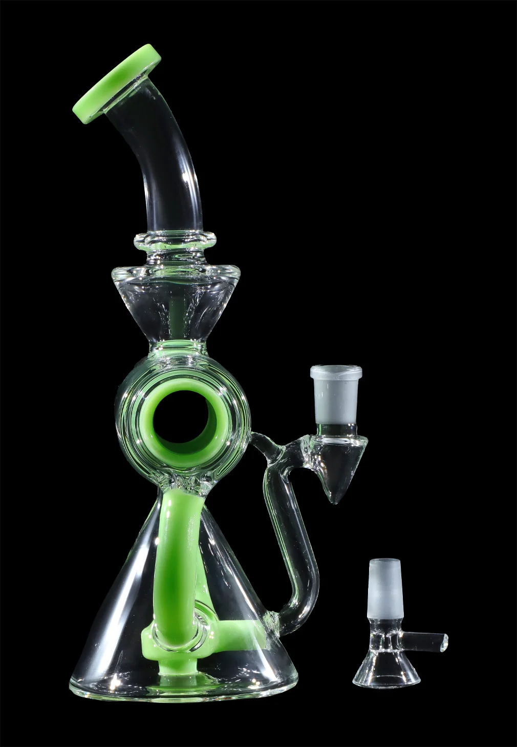 Green glass dab rig with accompanying glass bowl and carb cap, isolated on a black background.
