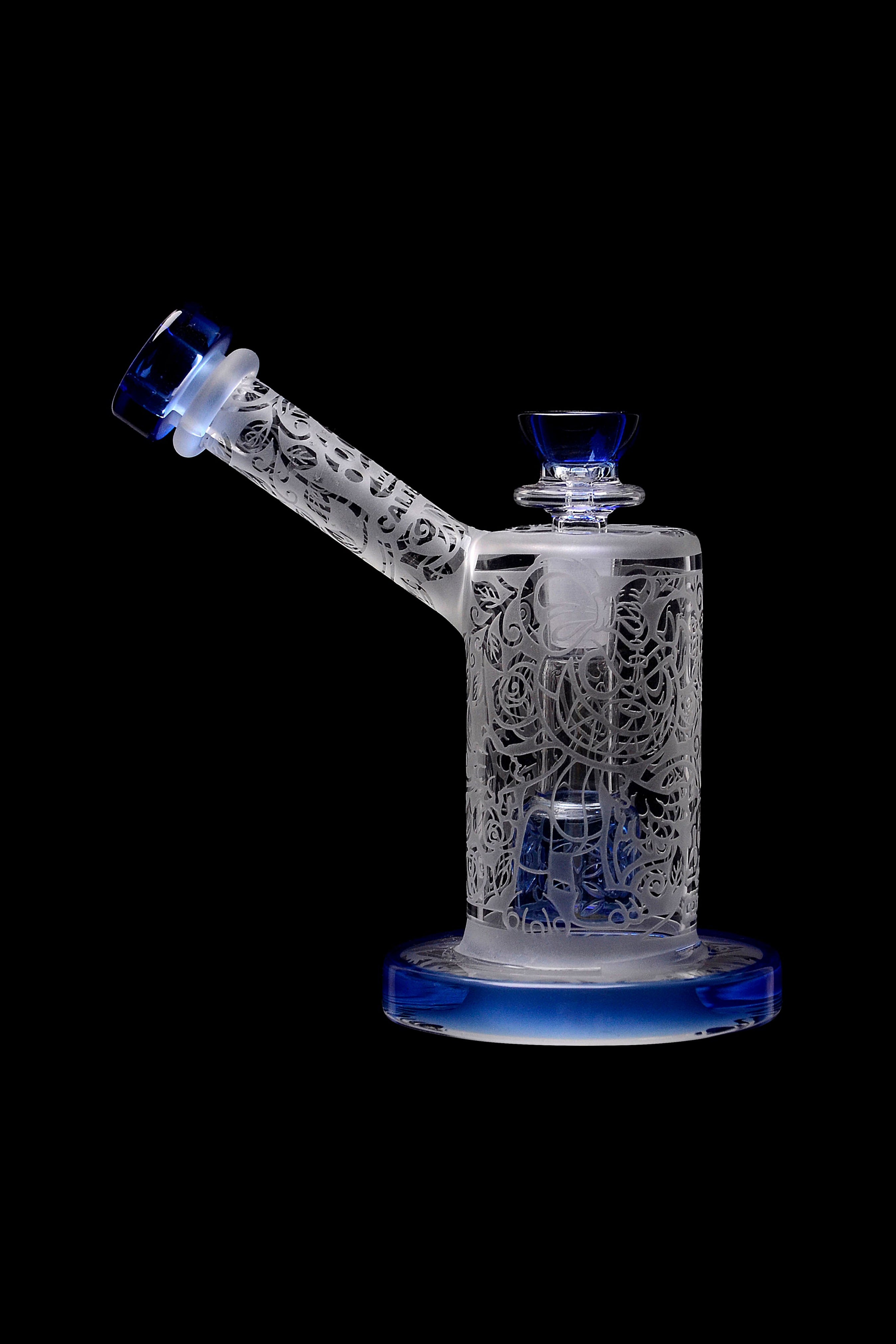 Intricate glass water pipe (bong) with floral cutouts and blue accents, isolated on a black background.