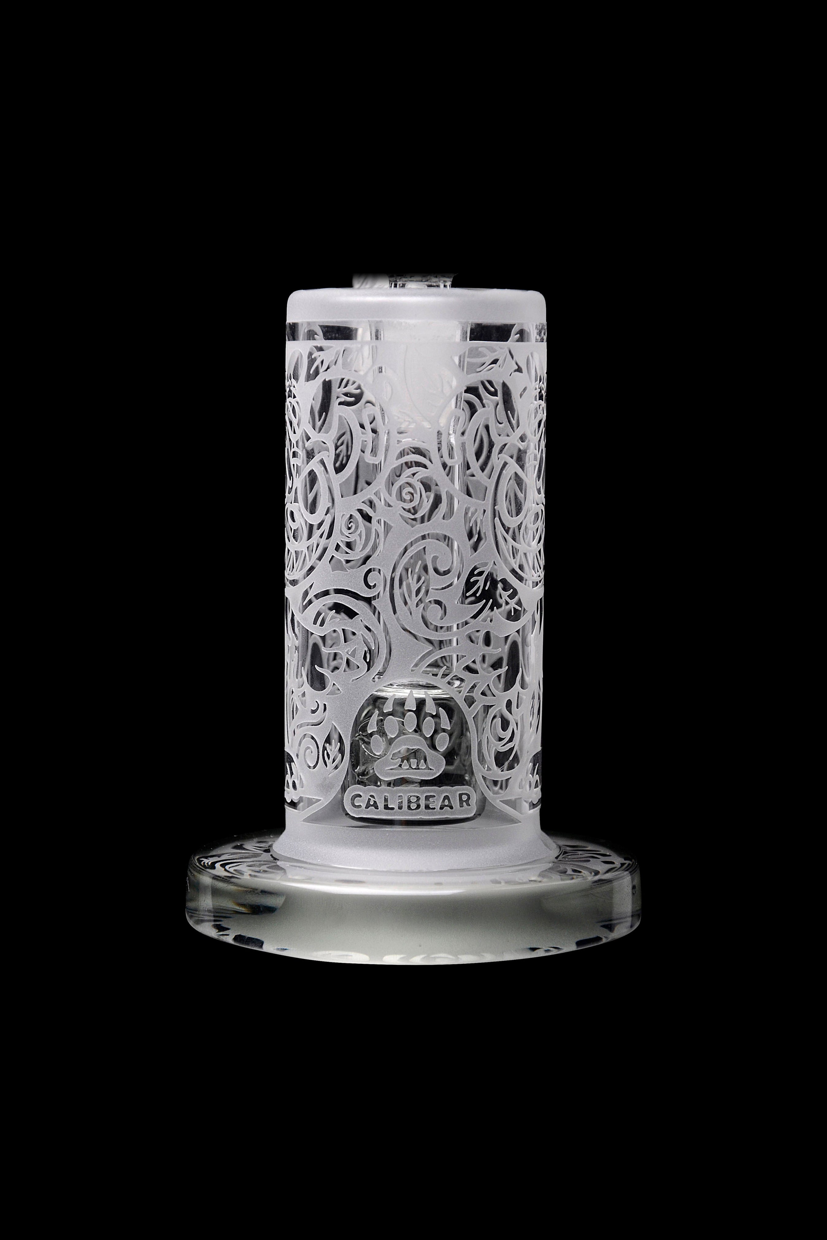 Clear glass bubbler with ornate floral carving and “Calibear” logo, isolated on a black background.