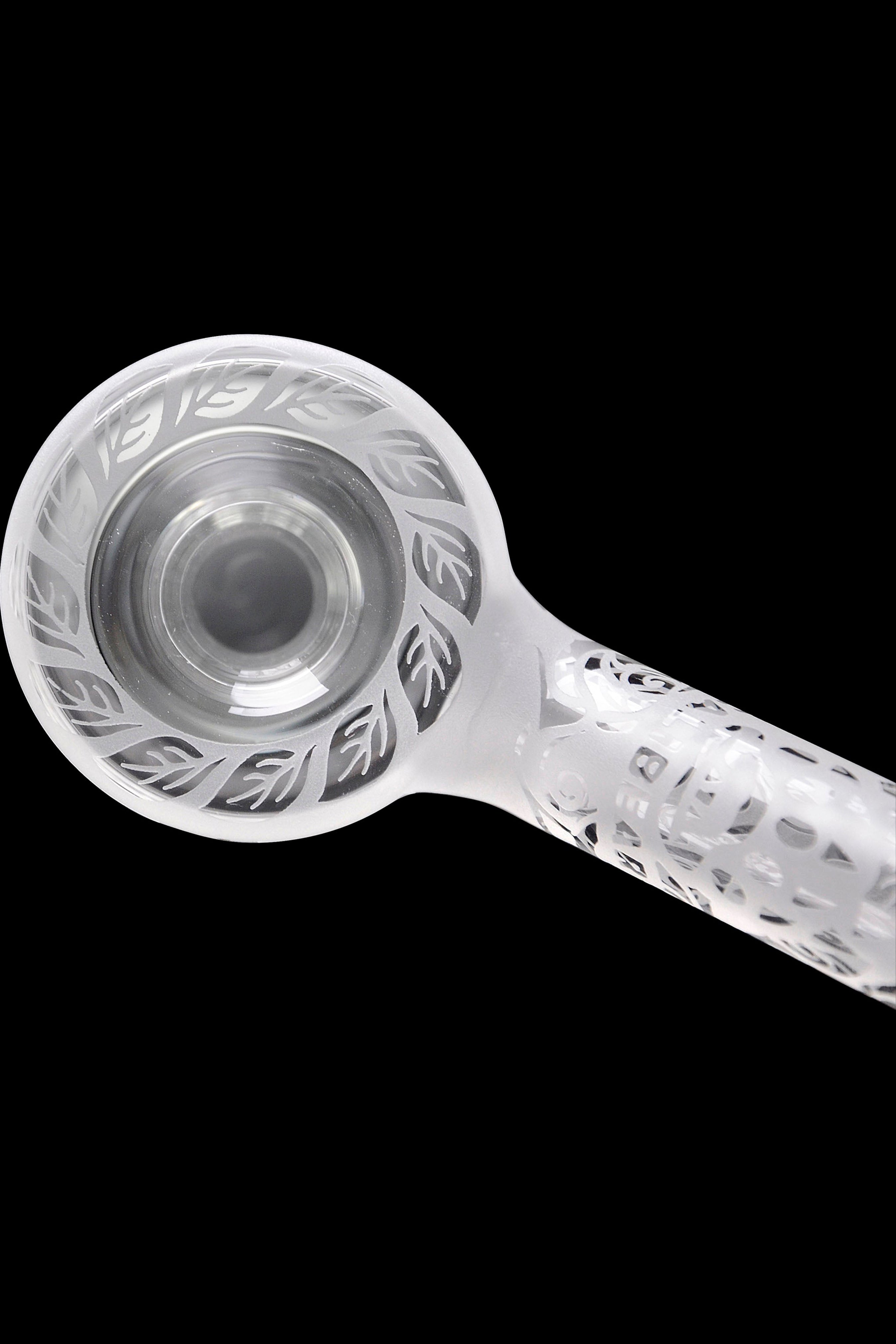 Clear glass pipe with intricate leaf patterns, isolated on a black background.