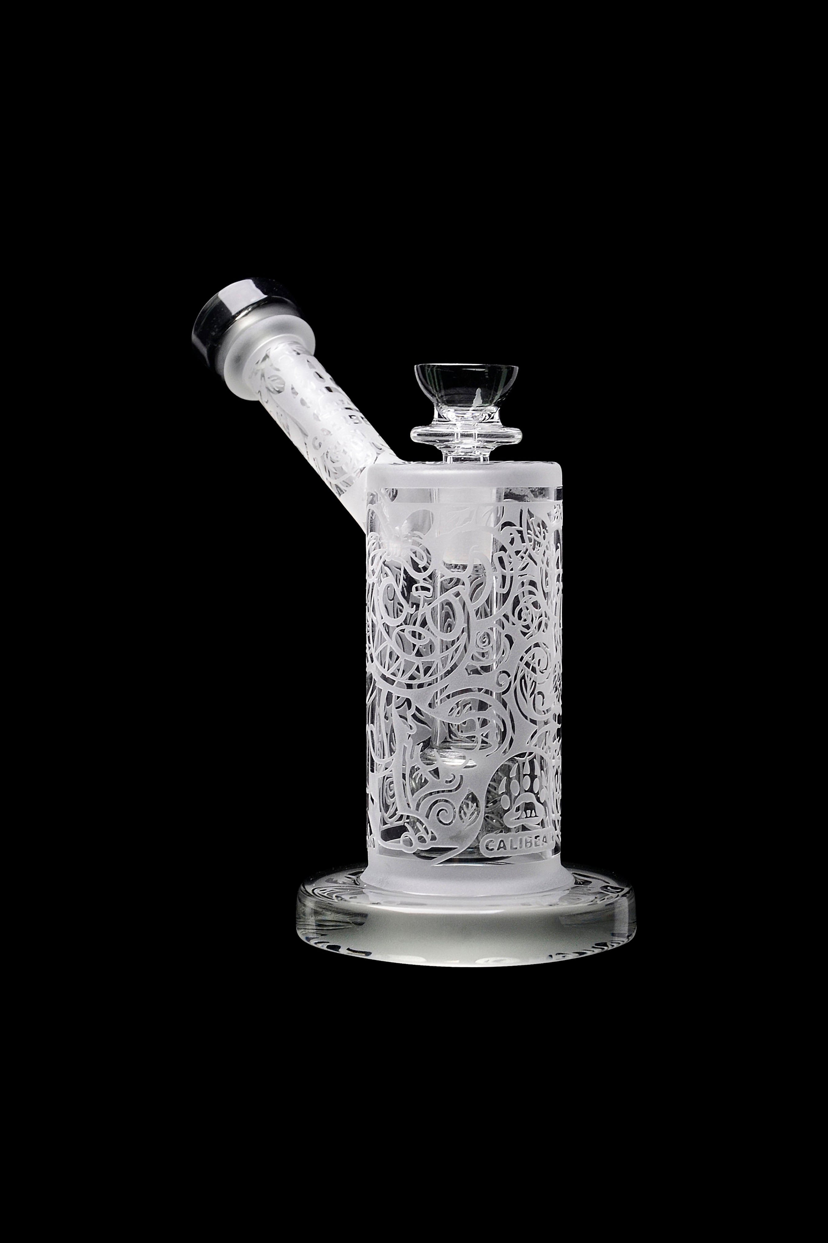 Frosted glass water pipe (rig) with intricate floral carvings, isolated on black.
