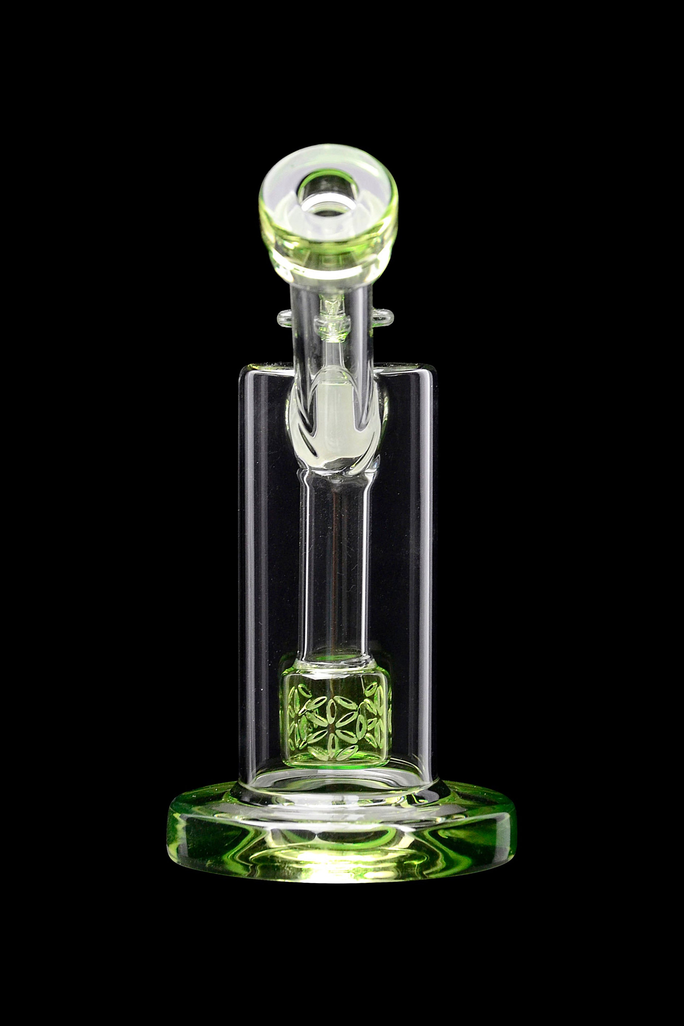 Green glass rig with intricate floral design, isolated on black.
