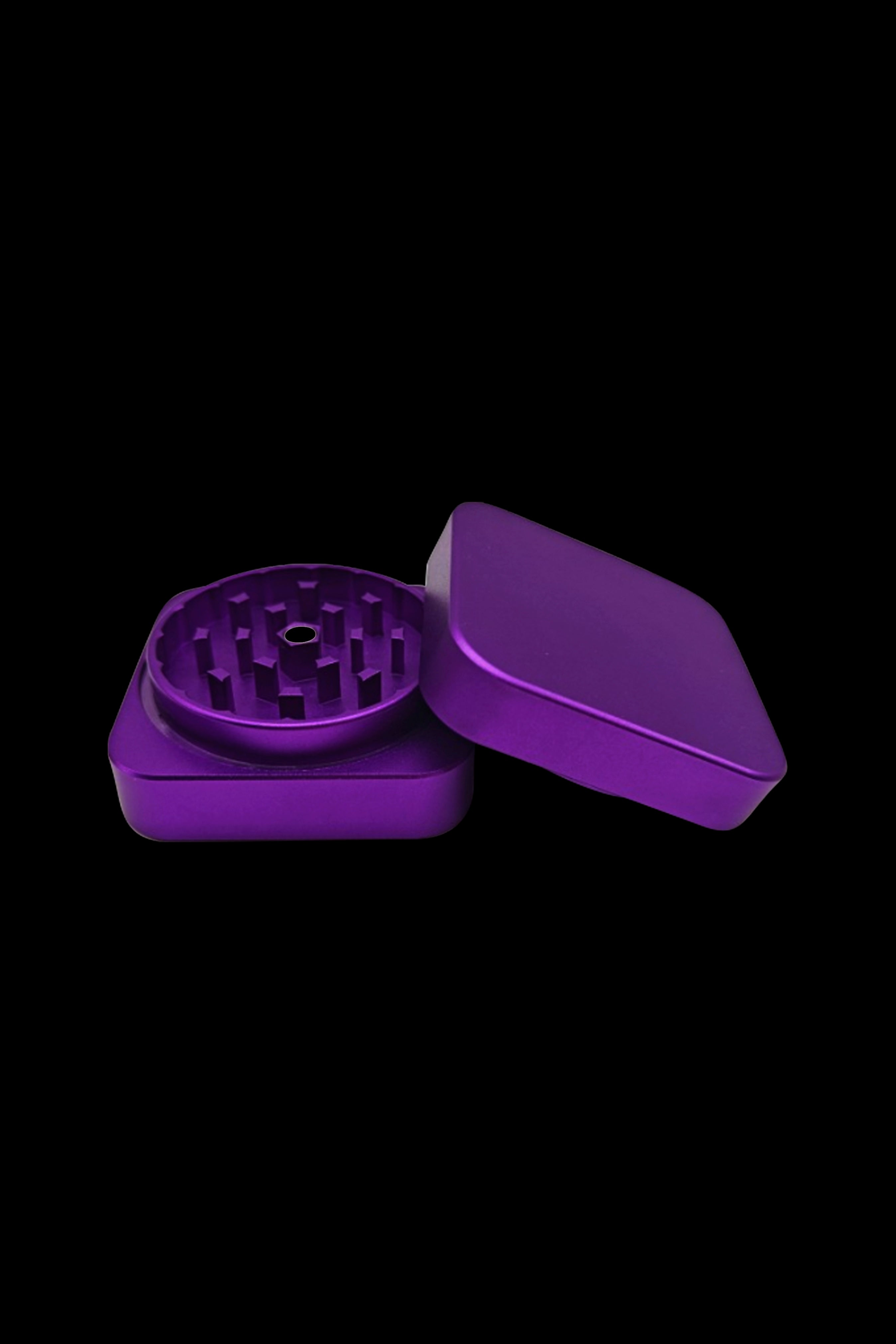 Purple cannabis grinder, open, on a black background.