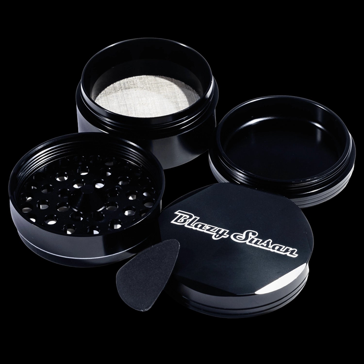 Angled top-down view of the black Blazy Susan 4-pc 3 Chamber Grinder showing its open threaded compartments, mesh screen, and lid.