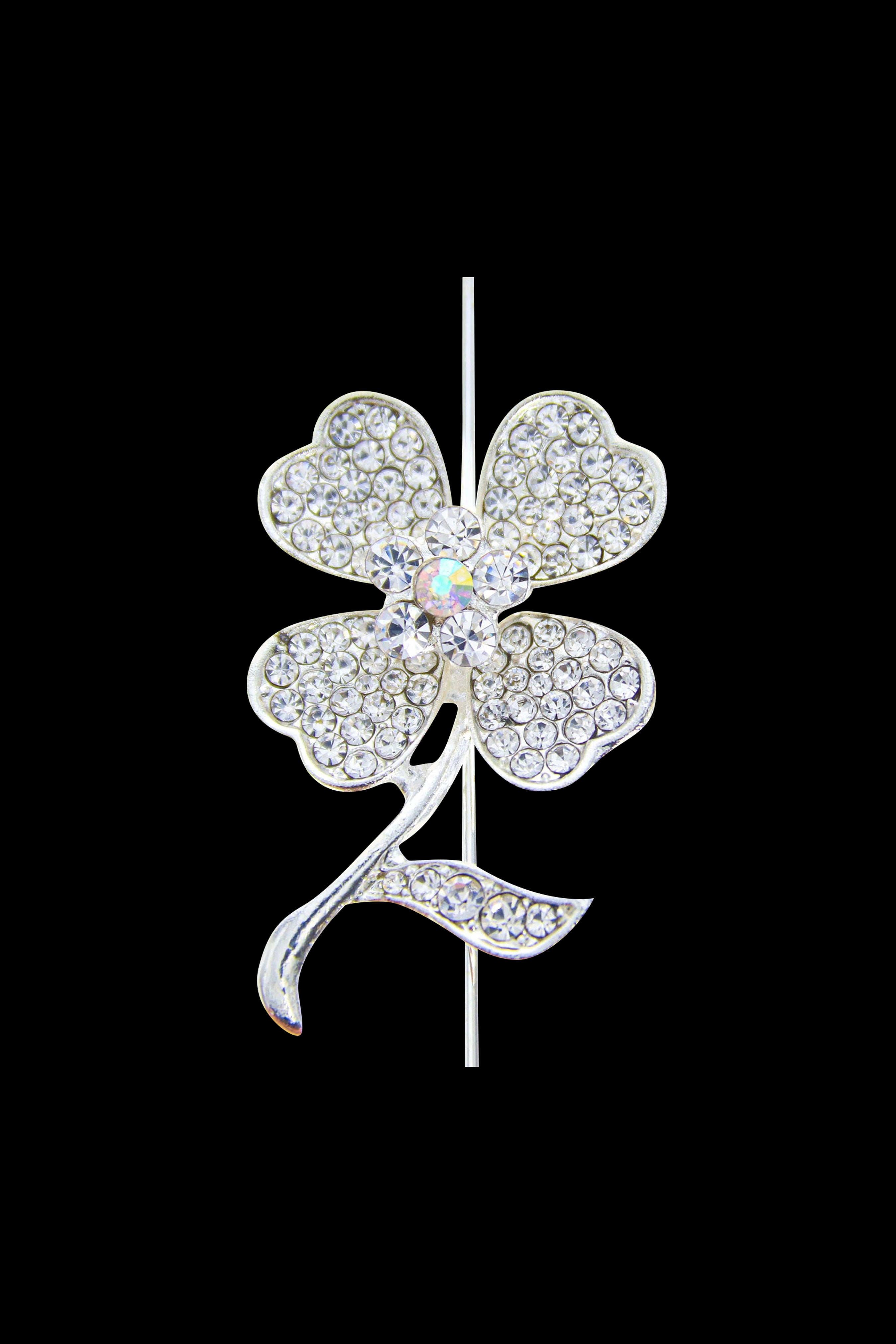 A close-up of a jeweled, four-leaf clover-shaped cannabis pipe against a black background.